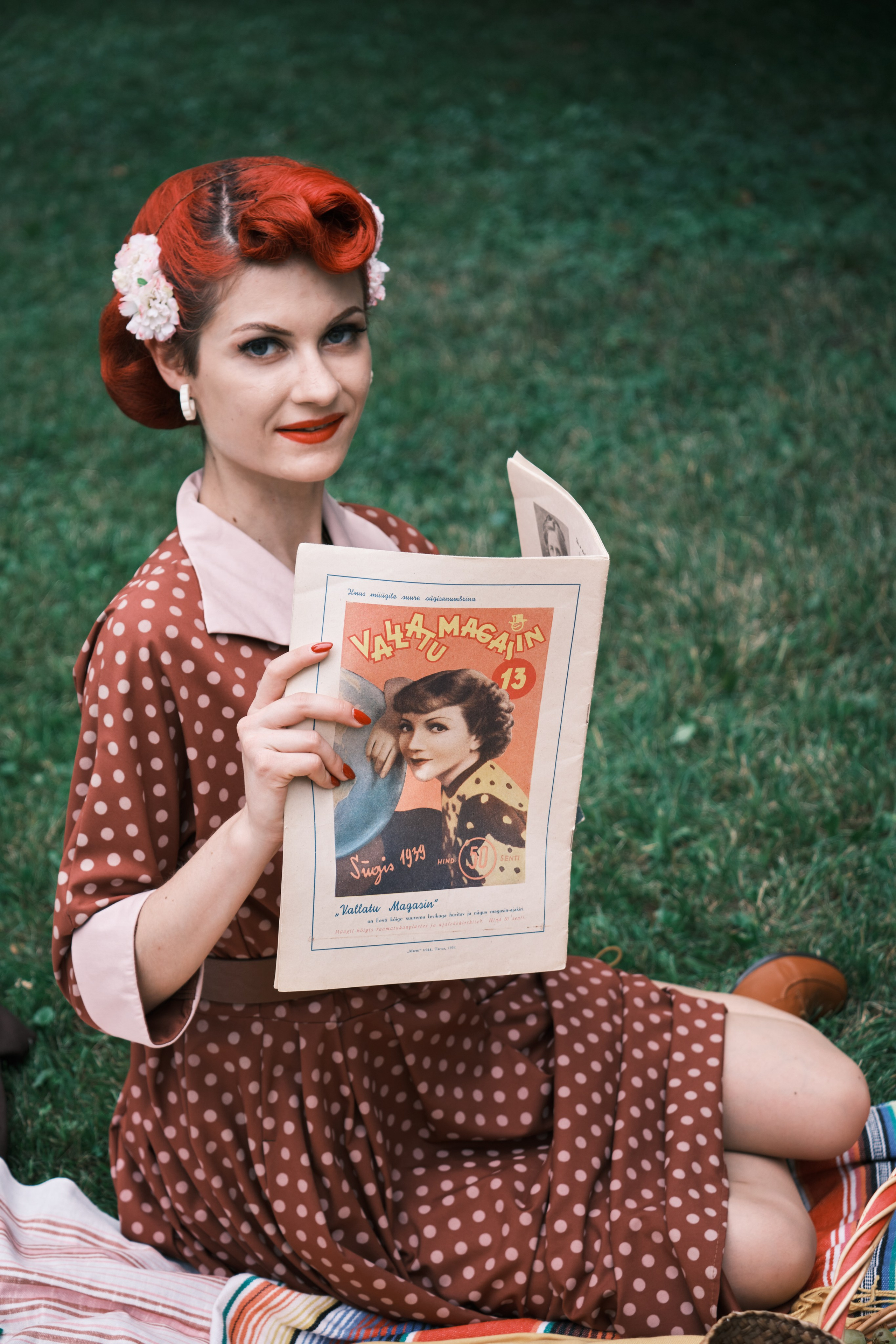 Девушка сидит на покрывале и читает журнал 1930 годов