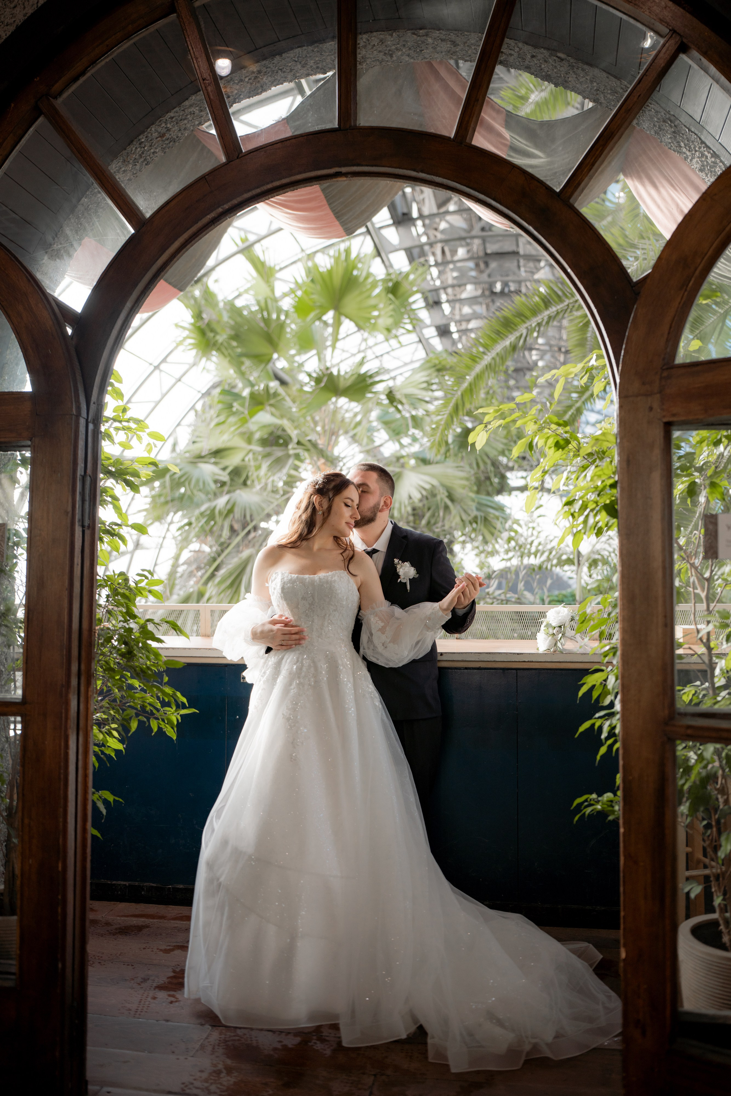 Свадебная фотография в Оранжерее Таврического сада Санкт-Петербурге. Стоят в проеме красивой двери