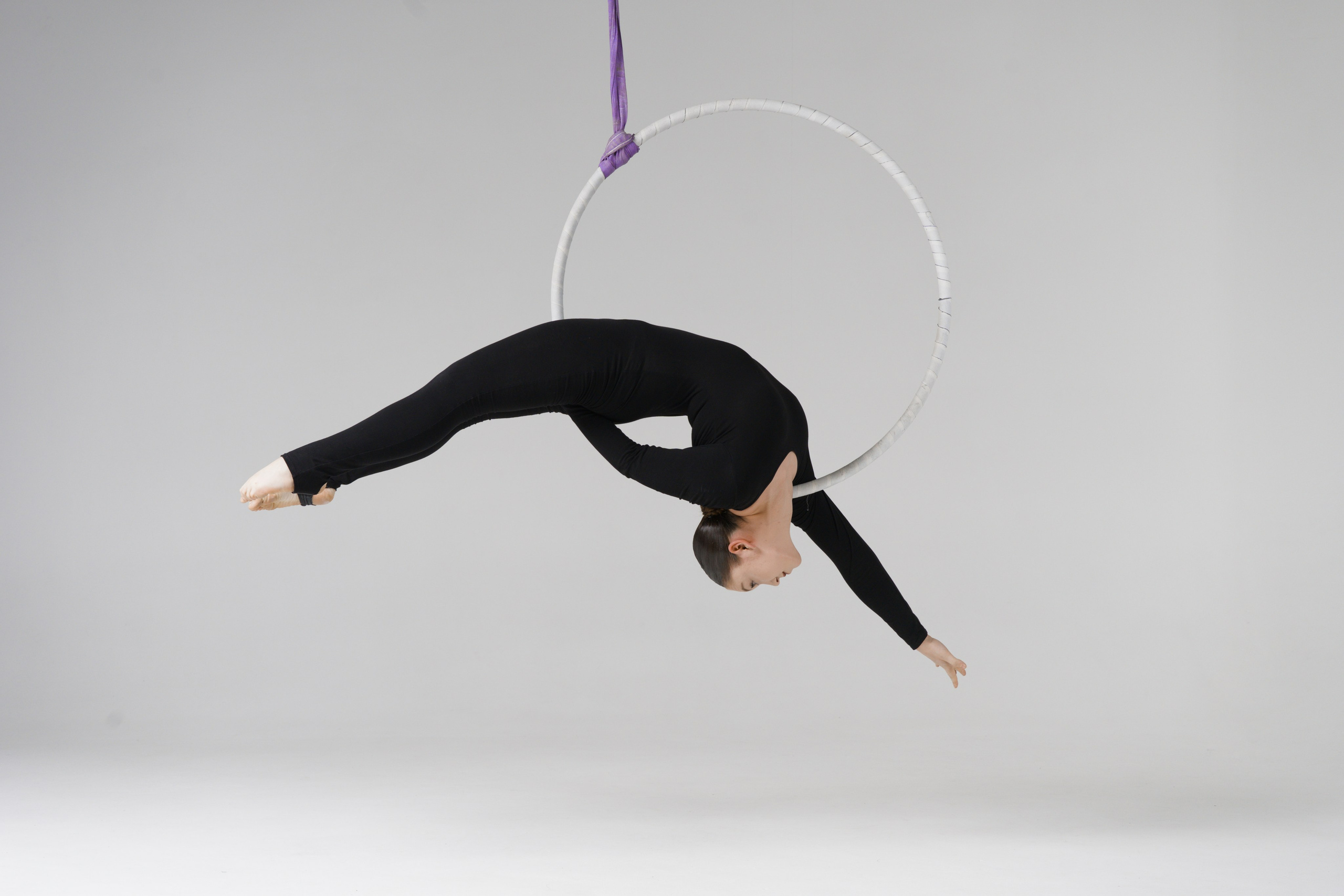 Демонстрация предельной гибкости на воздушном обруче, эстетика и контроль тела в профессиональном кадре