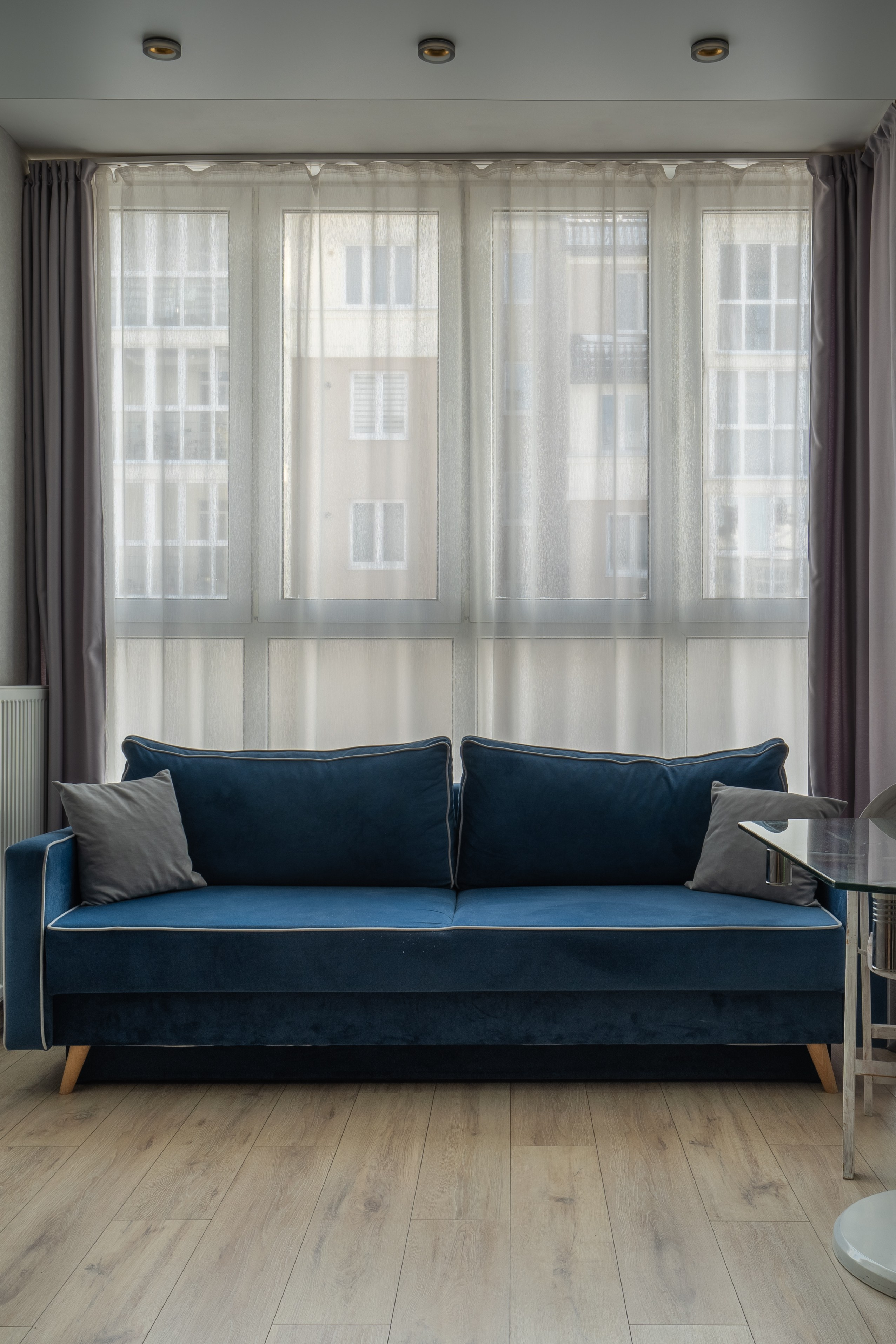 Большое панорамное окно и диван на переднем плане