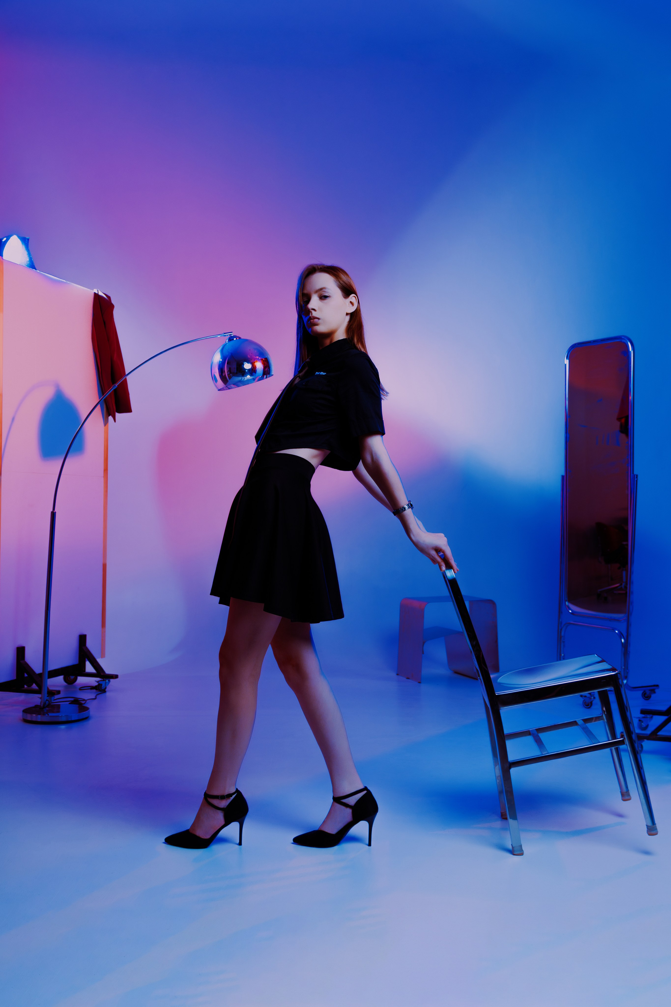 Современная студийная съёмка: поза модели на стуле говорит больше слов, чем тысячи фраз. Профессиональное освещение подчёркивает детали образа.