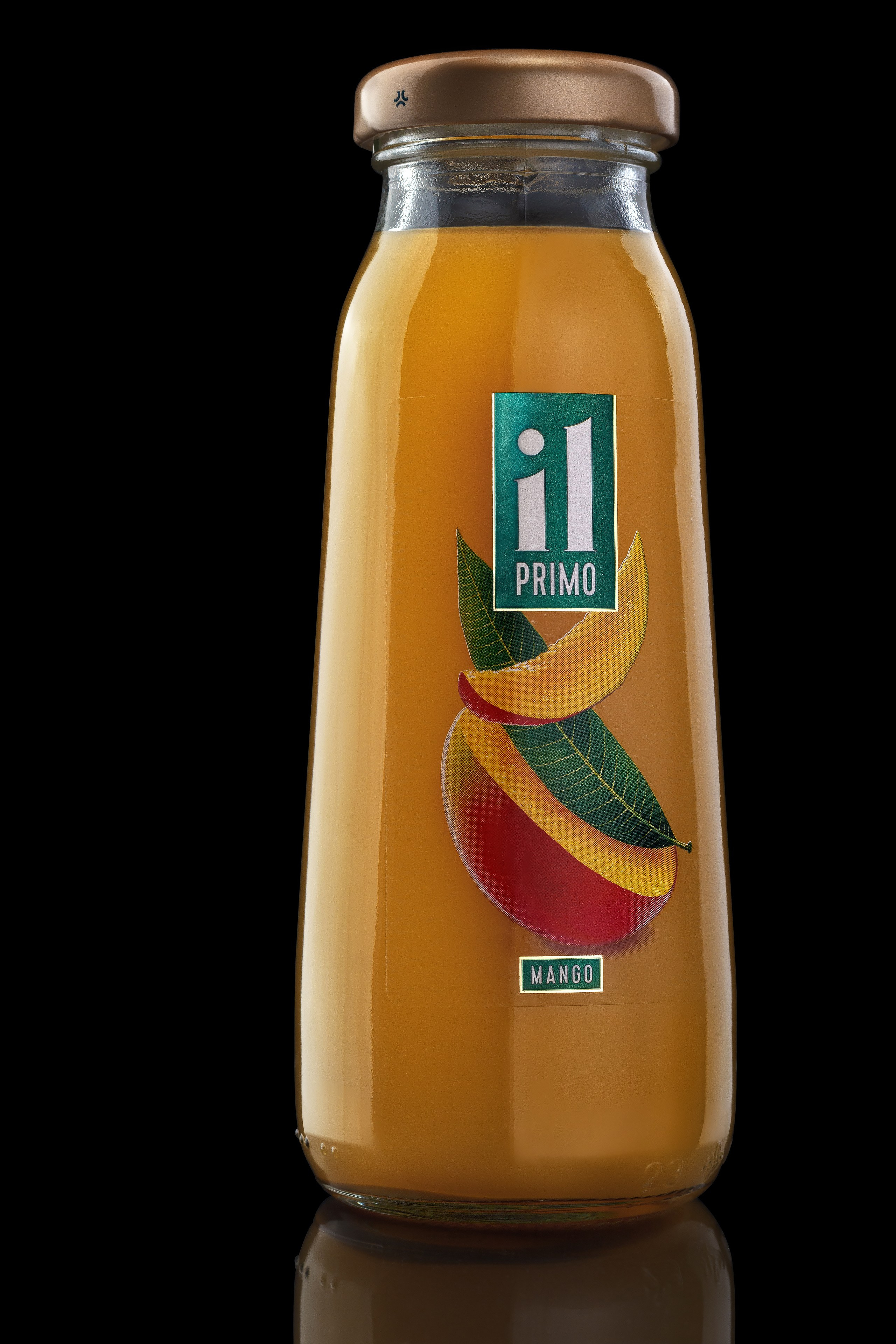 Сок манго в стеклянной бутылке чёрный фон каталожное фото