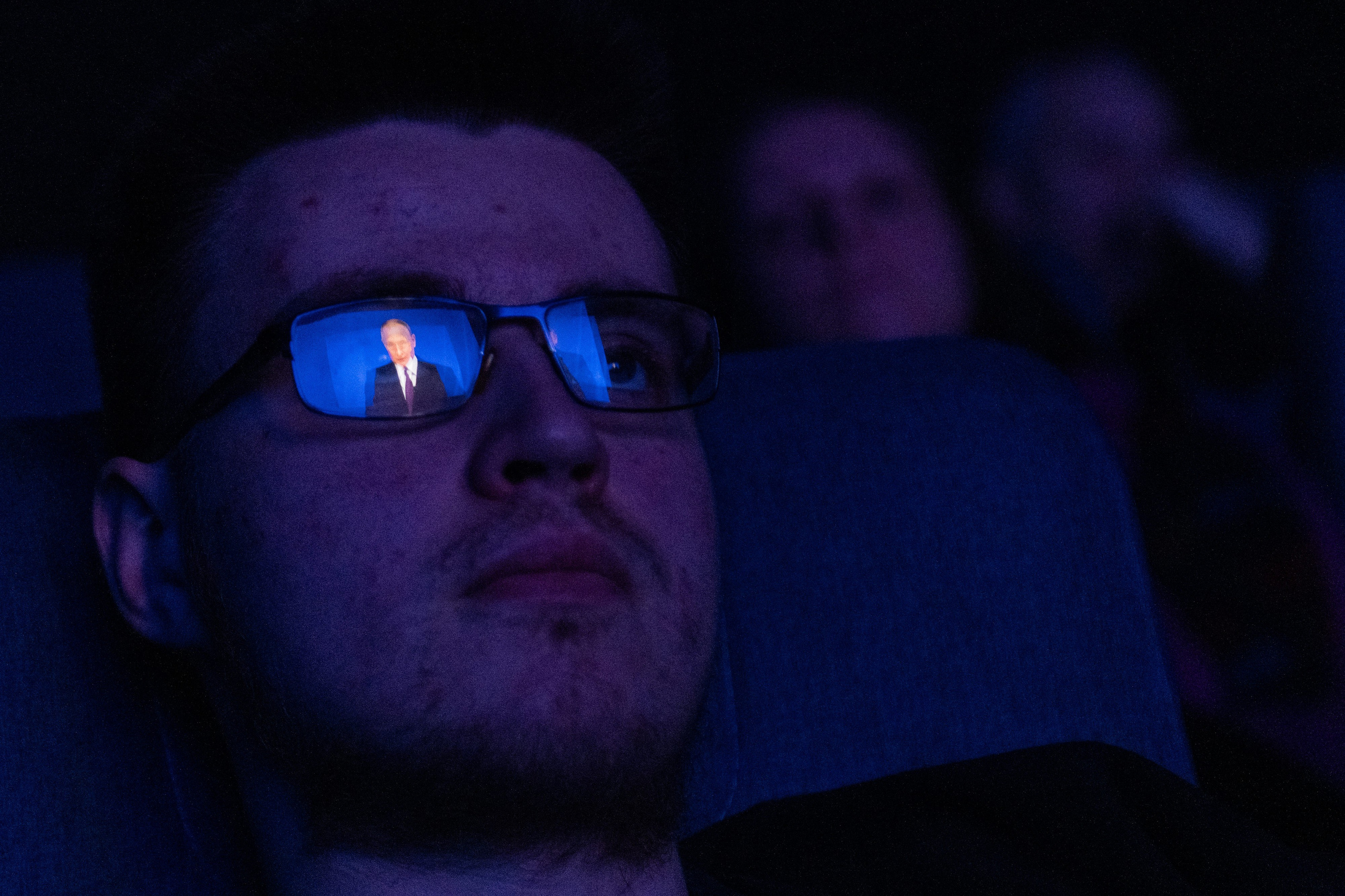 The President of Russia, Vladimir Putin, is reflected in a viewer's sunglasses during a broadcast of his address in a movie theater. St. Petersburg, February 29, 2024.