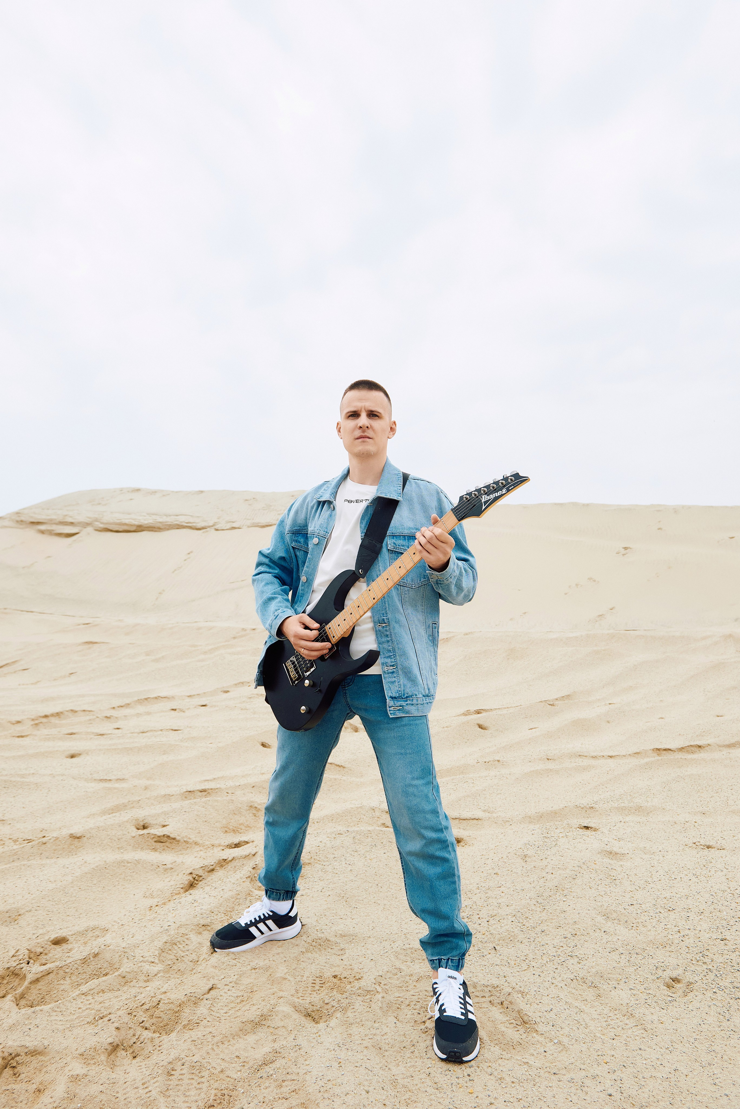 Парень играет на гитаре в пустыне