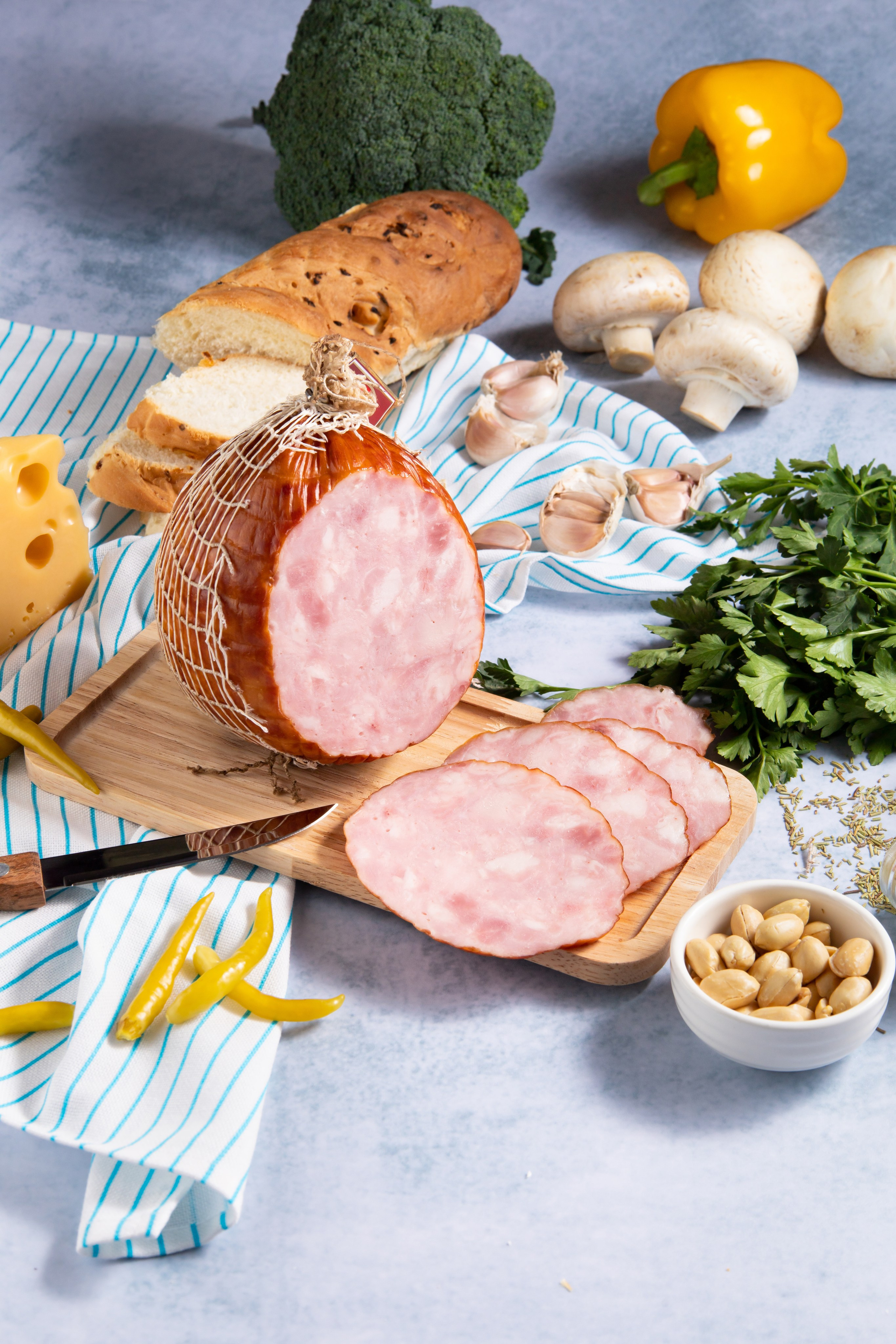 Рекламное фото ветчины рядом с овощами и зеленью