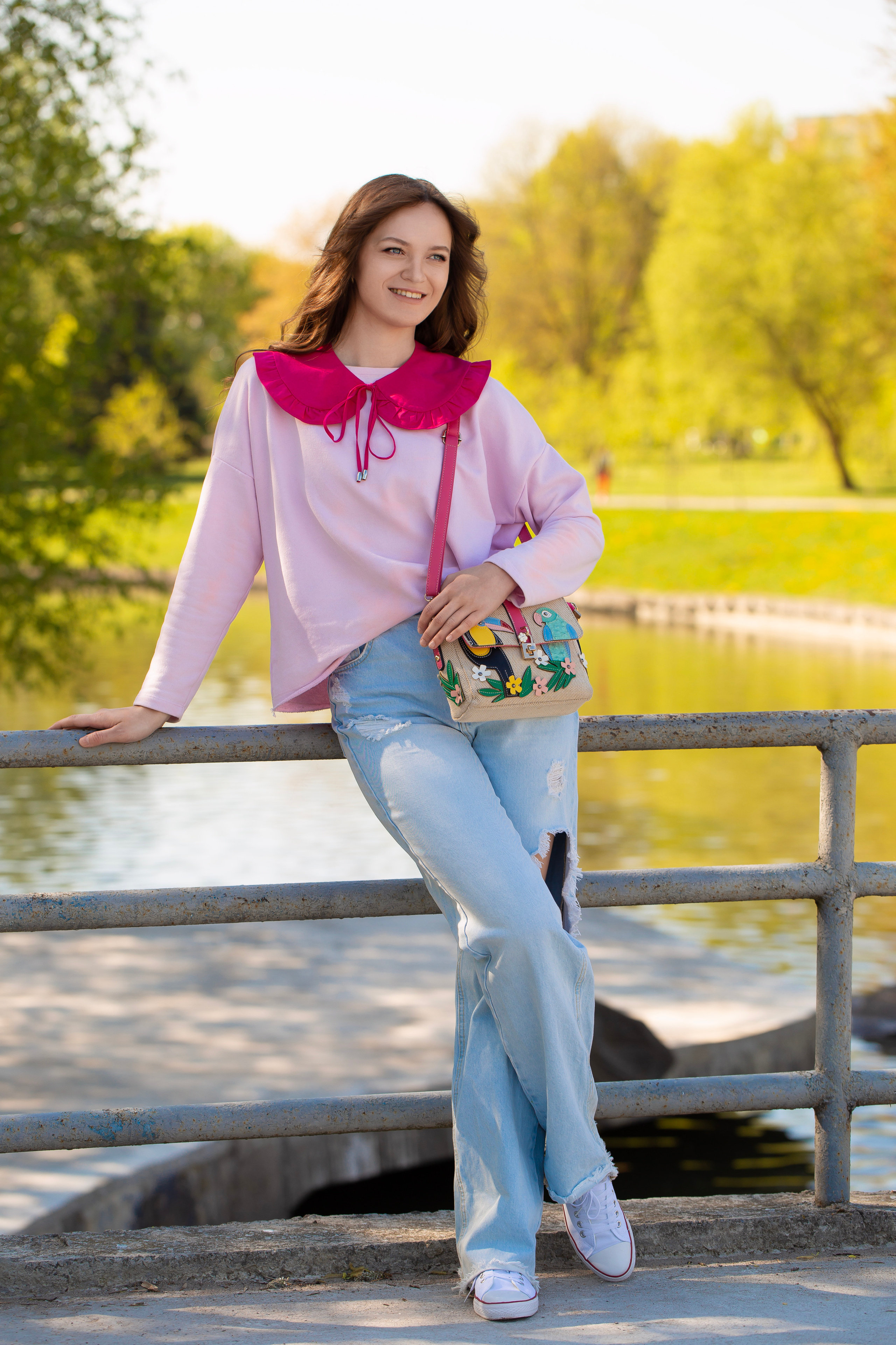 красивая стройная модель в весеннем парке на мосту 