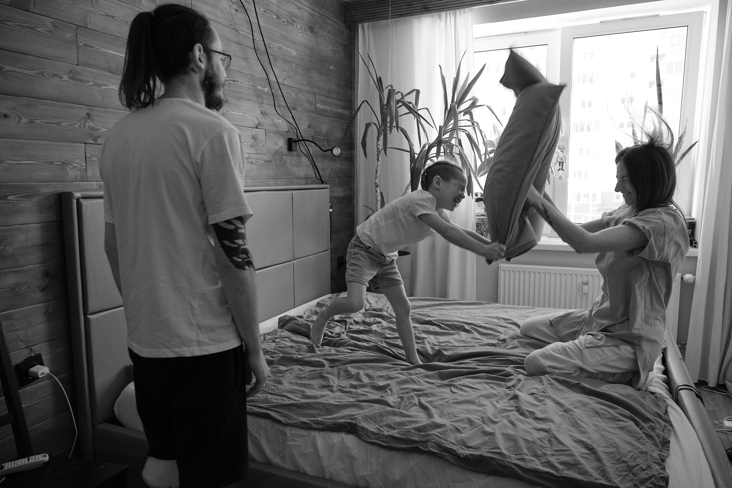 Бой подушками дома на кровати. Живая семейная фотосессия, Санкт-Петербург