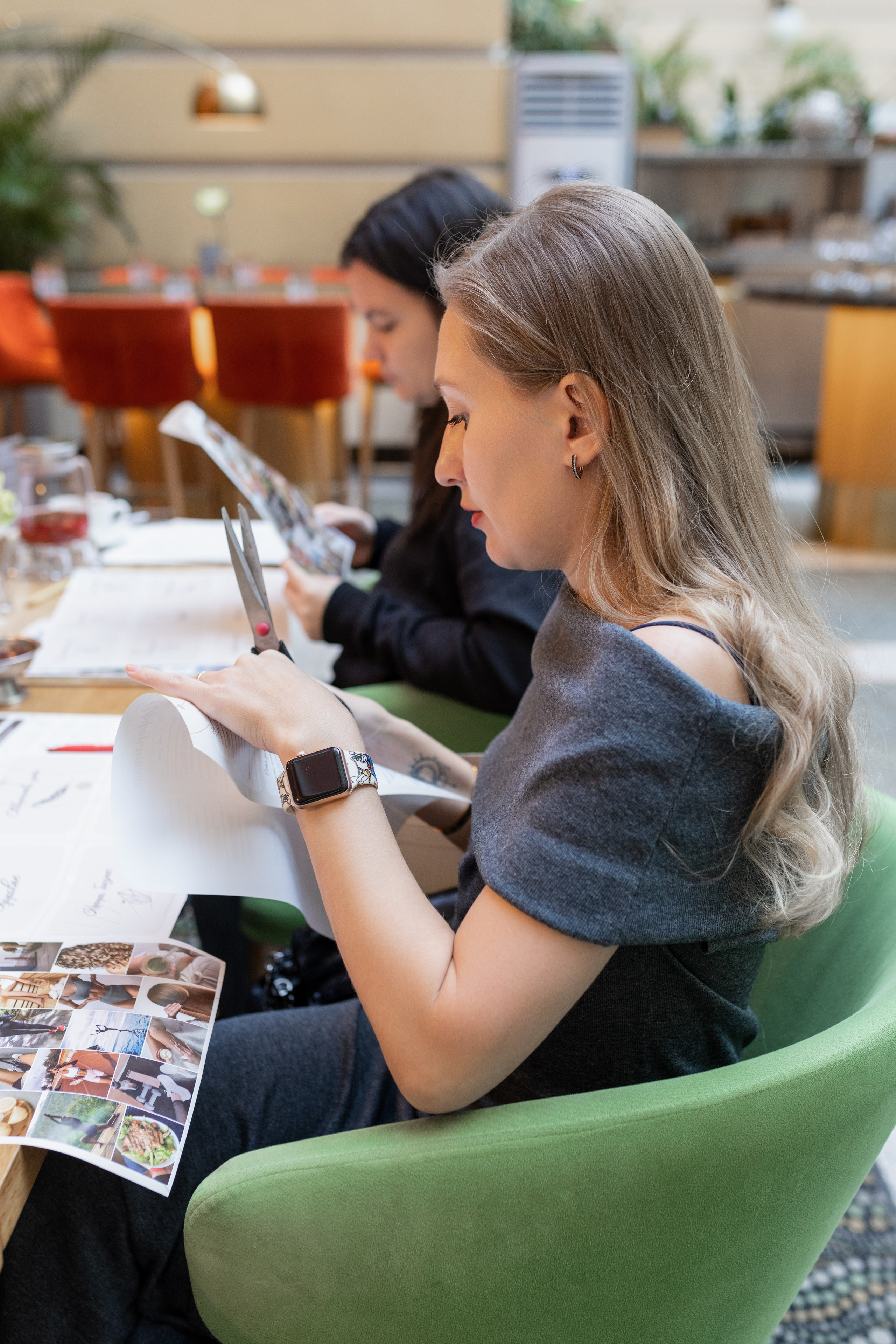 Девушки за столом, они внимательно вырезают картинки