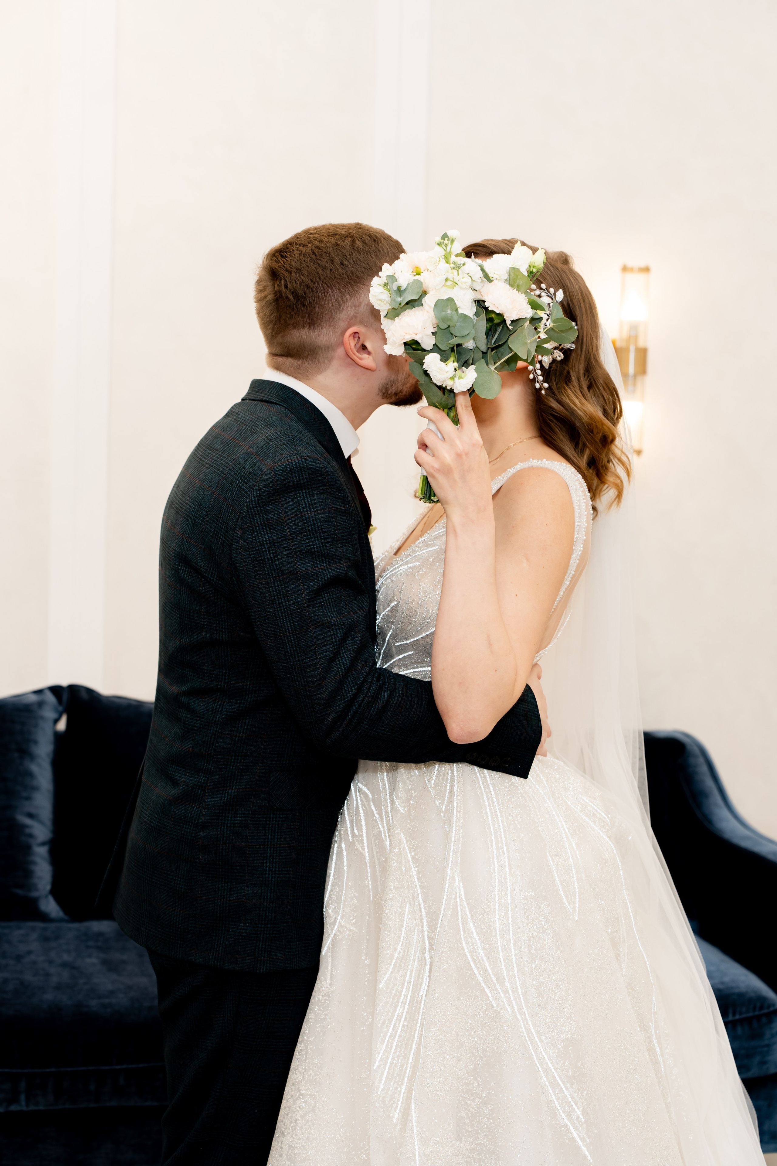 Жених целует невесту за букетом Москва