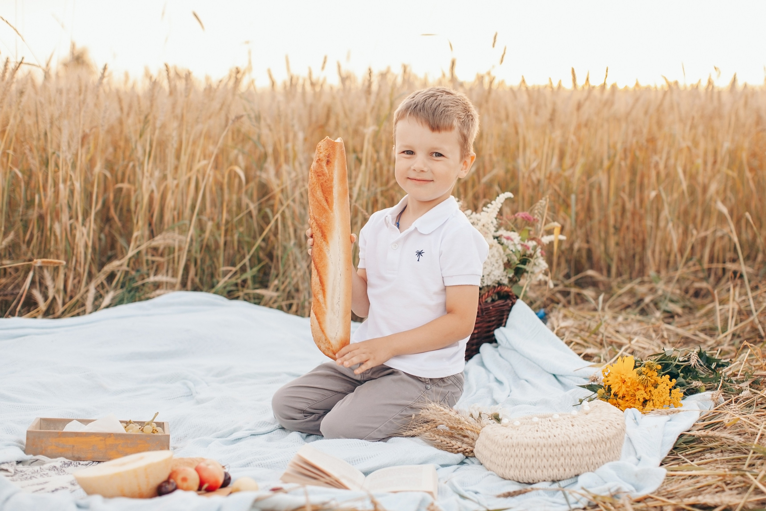 мальчик позирует на пикнике с багетом и вкусной едой