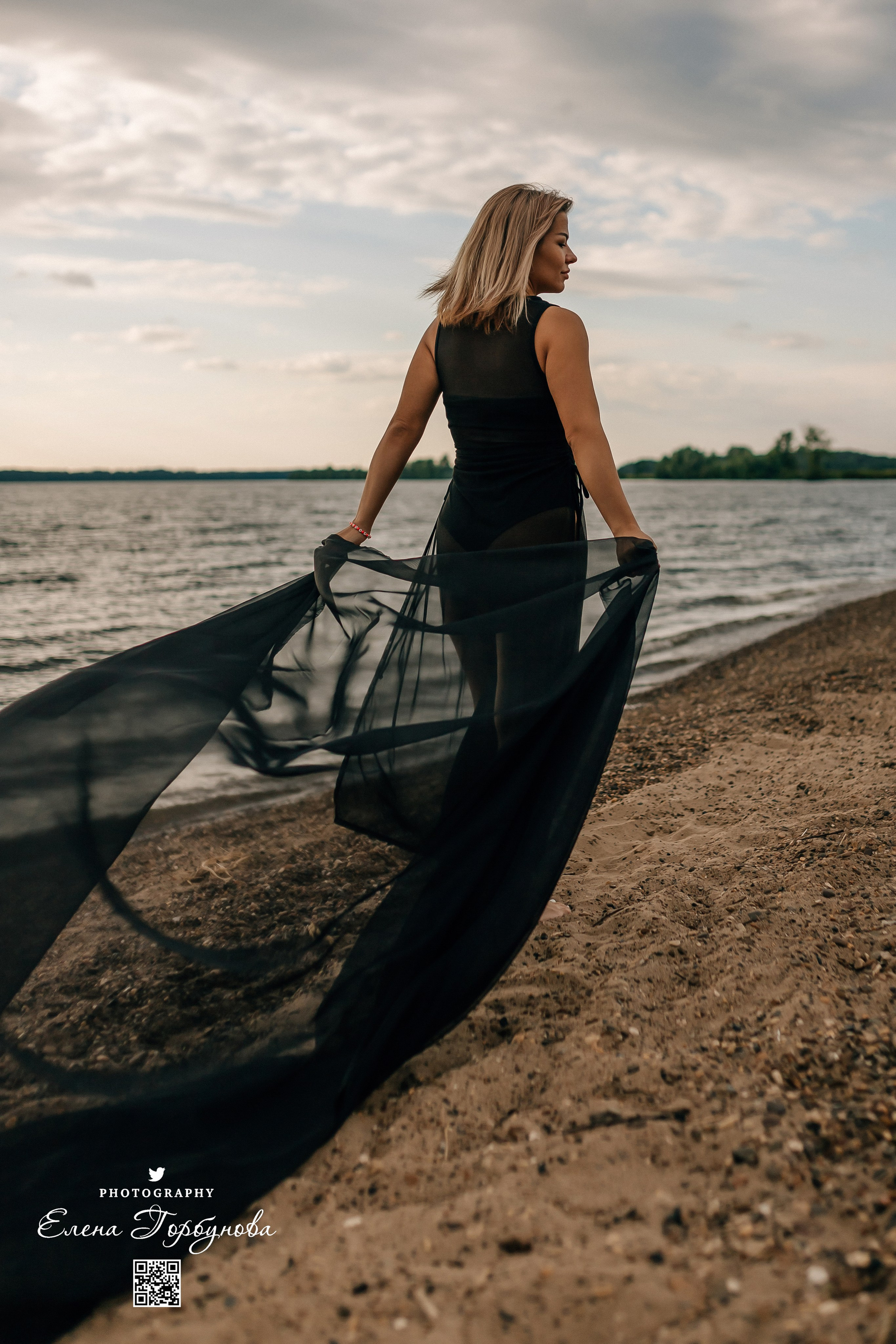 Фотосессия с черной тканью. Легкая черная вуаль летит на вертру. Фотосессия у реки черная серия с тканью. Девушка укуталась в черную ткань. Прогулка по набережной. Песок, речка, модель в черном. Качели над водой, Закат. Девушка лежит на песке. В зеленых деревьях