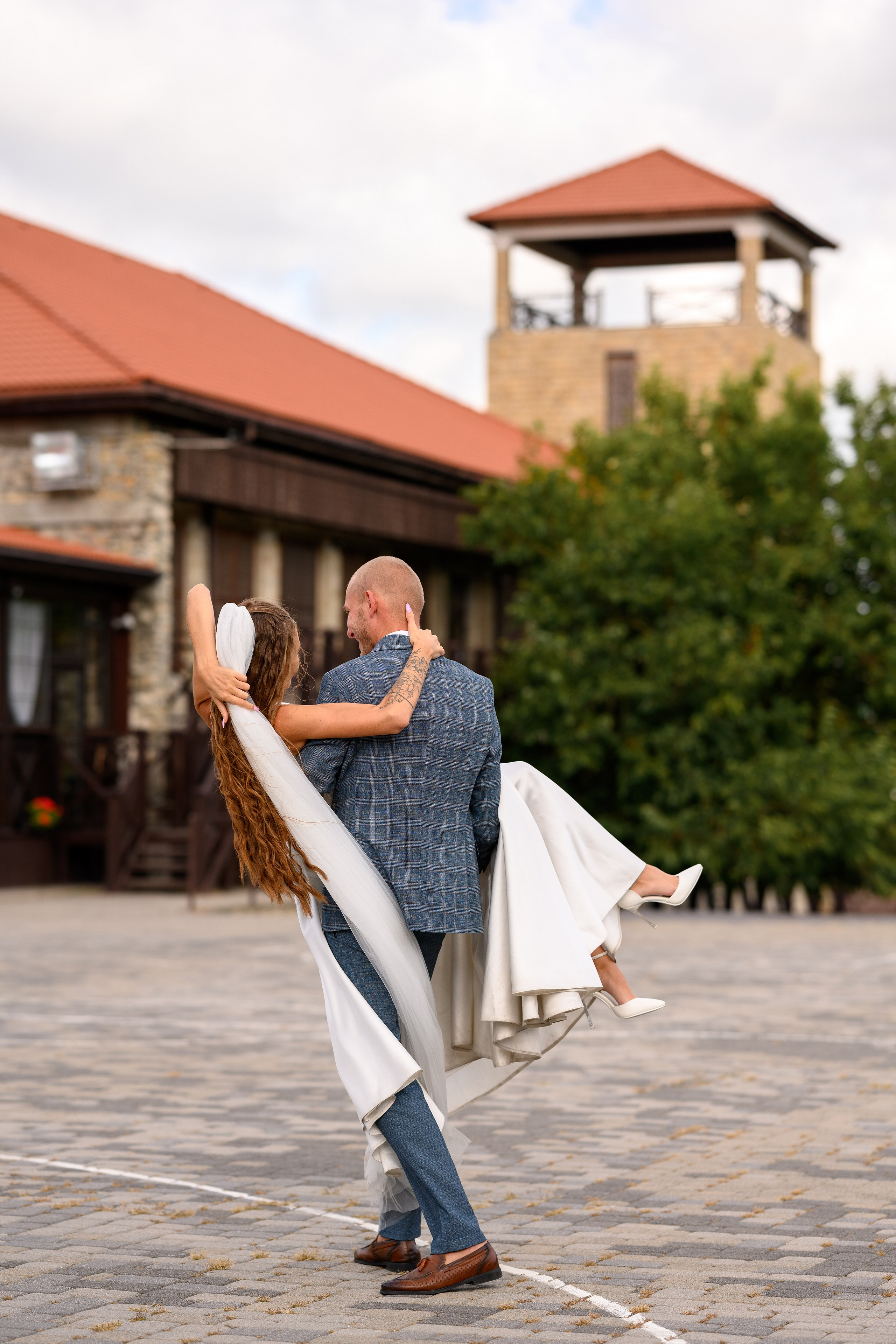 Жених несет невесту на руках.