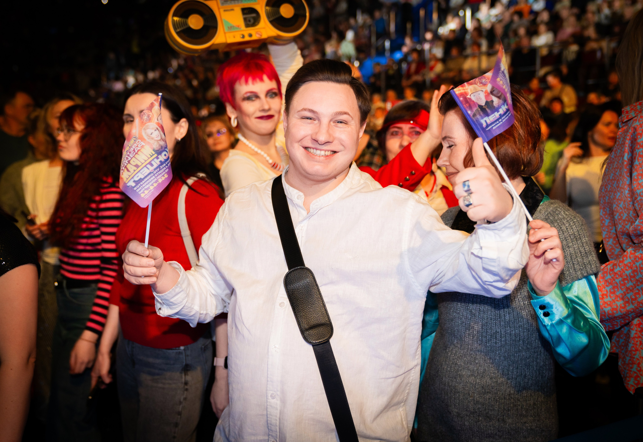 Улыбающийся молодой человек с флажком и thumbs up на концерте Светланы Разиной. День рождения компании Ленремонт в КСК Арена. Фото Евгения Мальцева.