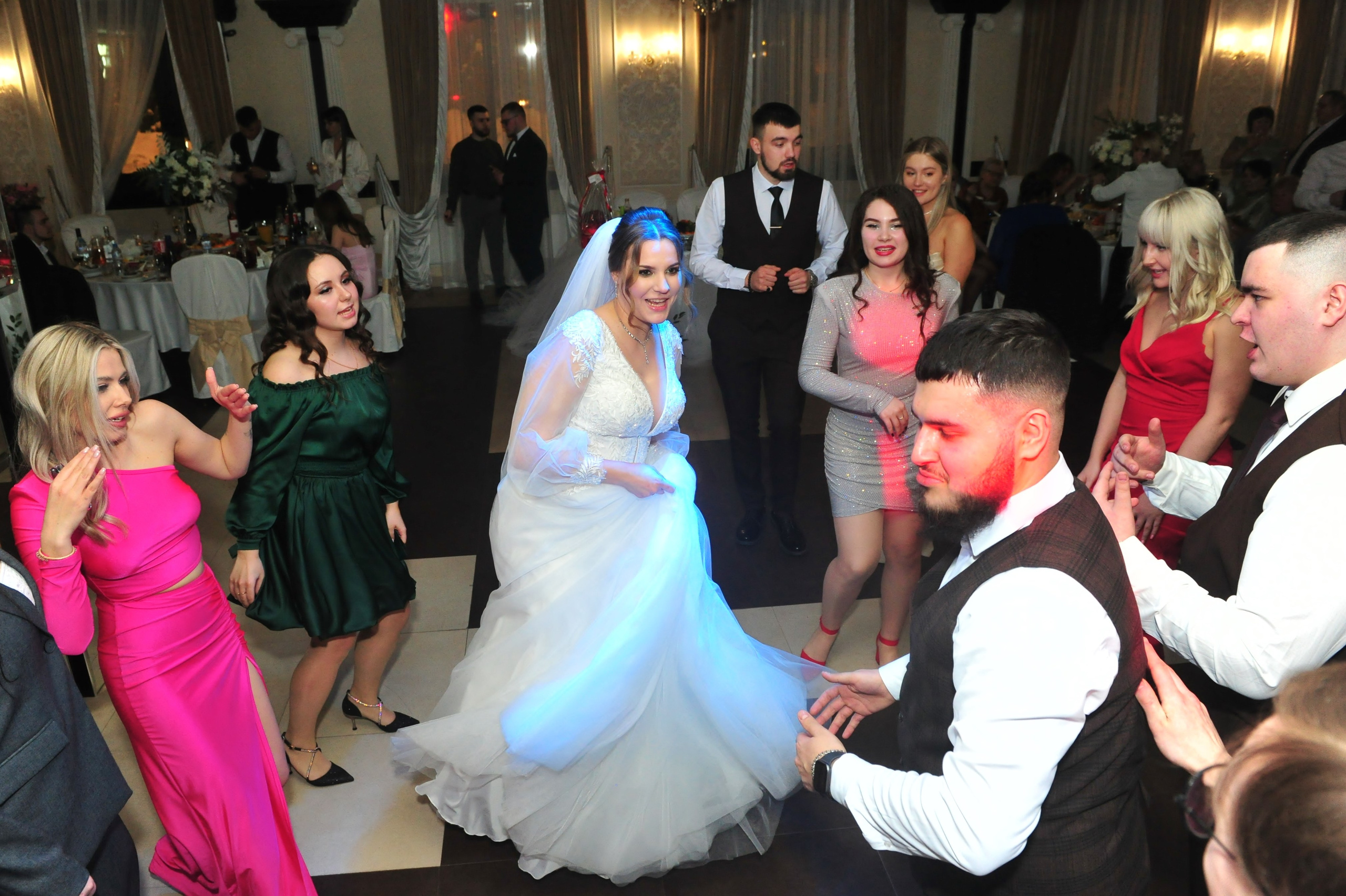 Невеста танцует среди гостей в ресторане