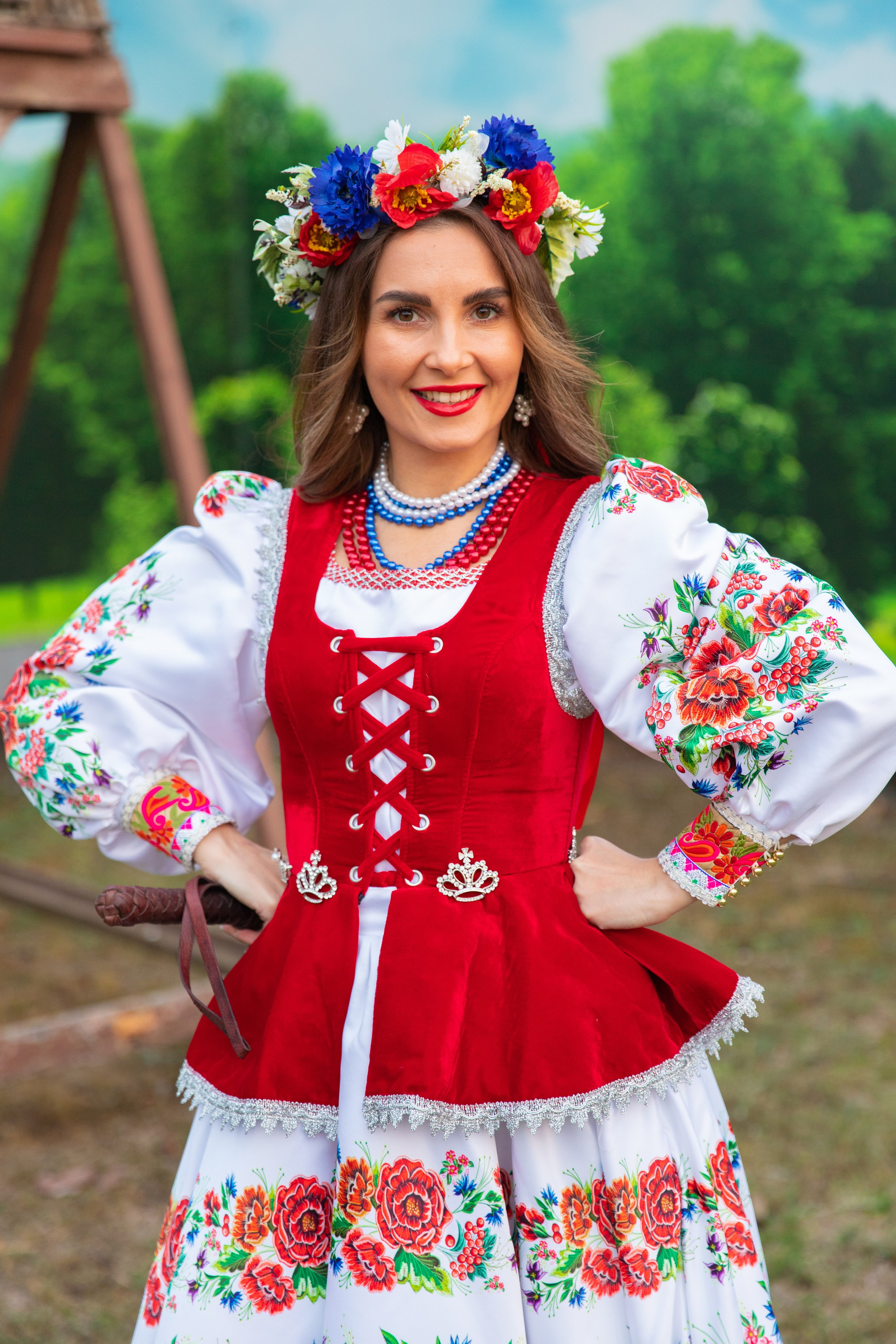 Внимание к деталям: молодая казачка показывает уникальные элементы своего платья, погружая в мир фольклора.