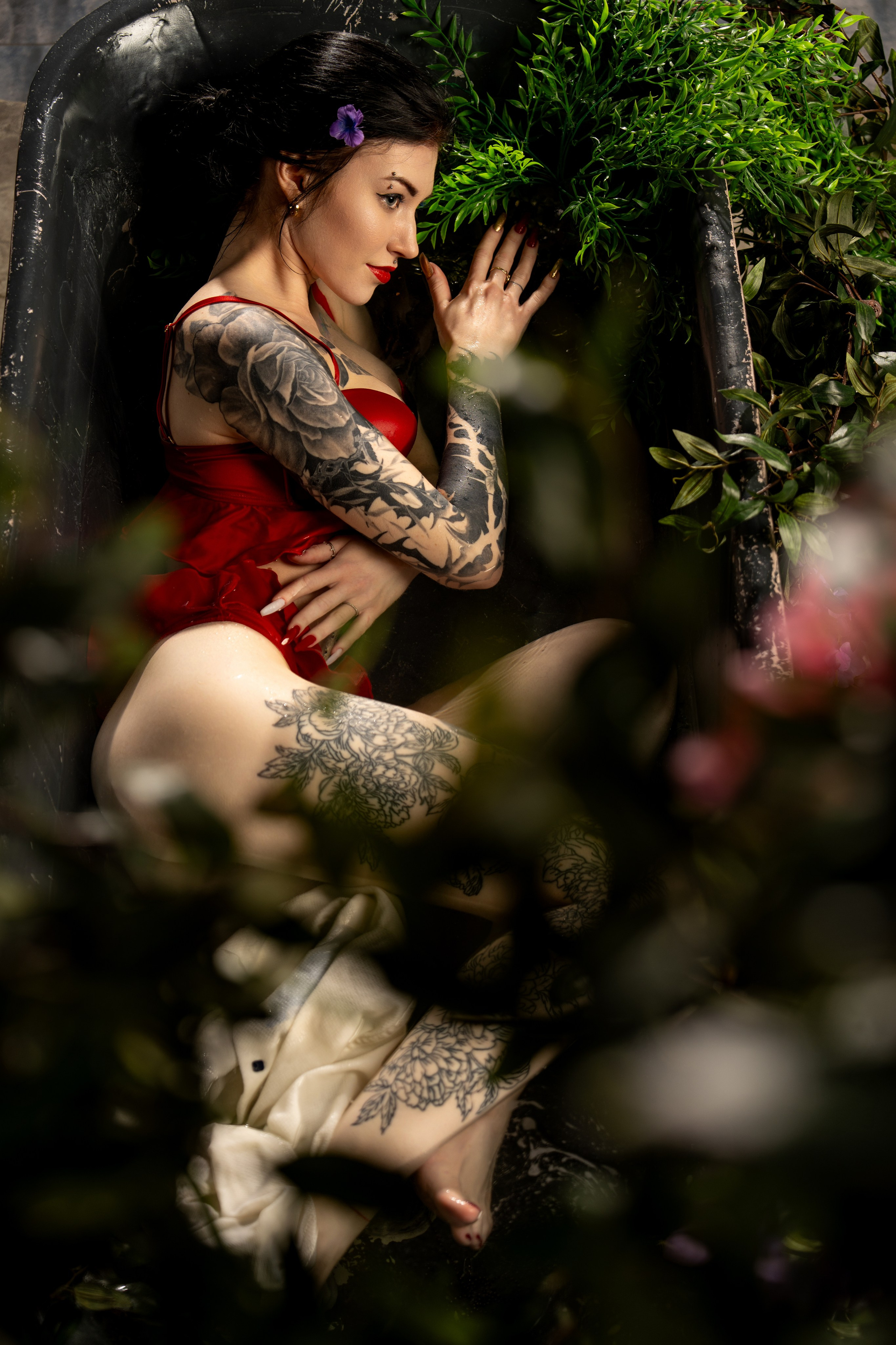 красивая ванна с цветами и растениями в которой лежит девушка в красном белье