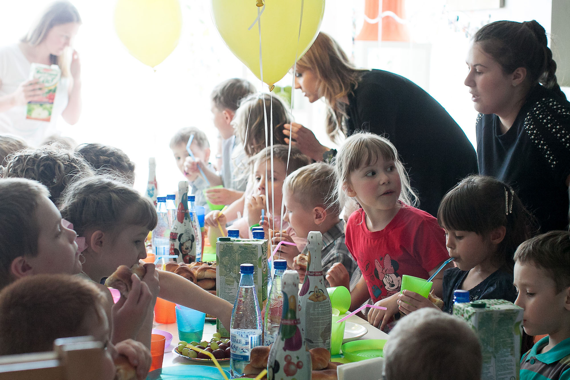 Выпускники детского сада и родители за праздничным столом.