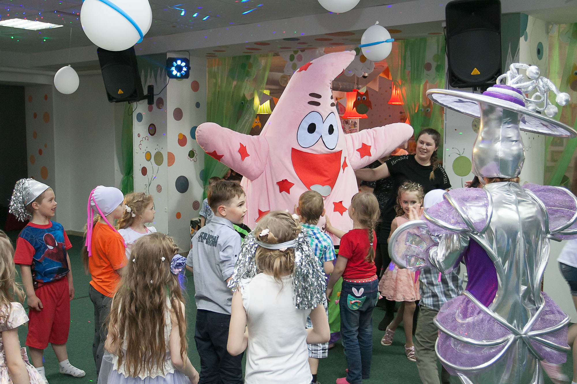 Дети в игровом центре с оранжевой звездой-аниматором.