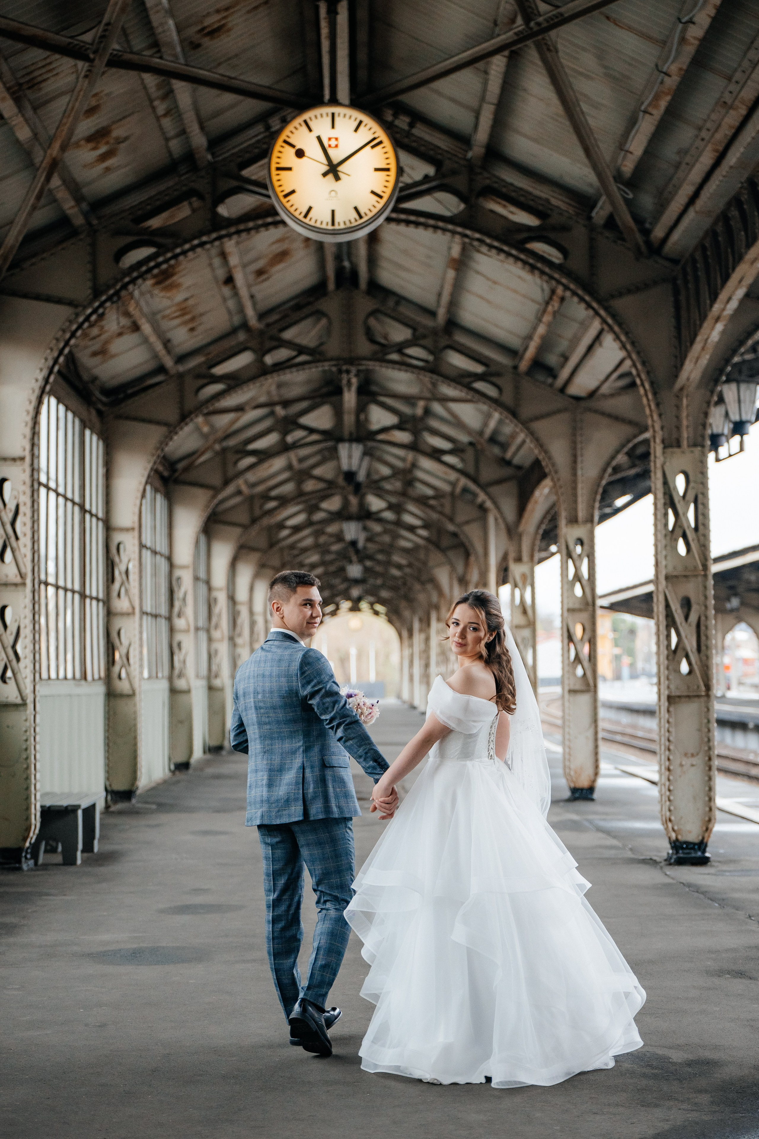 Свадебная фотосессия на Витебском вокзале в Санкт-Петербурге на перроне идут за руки