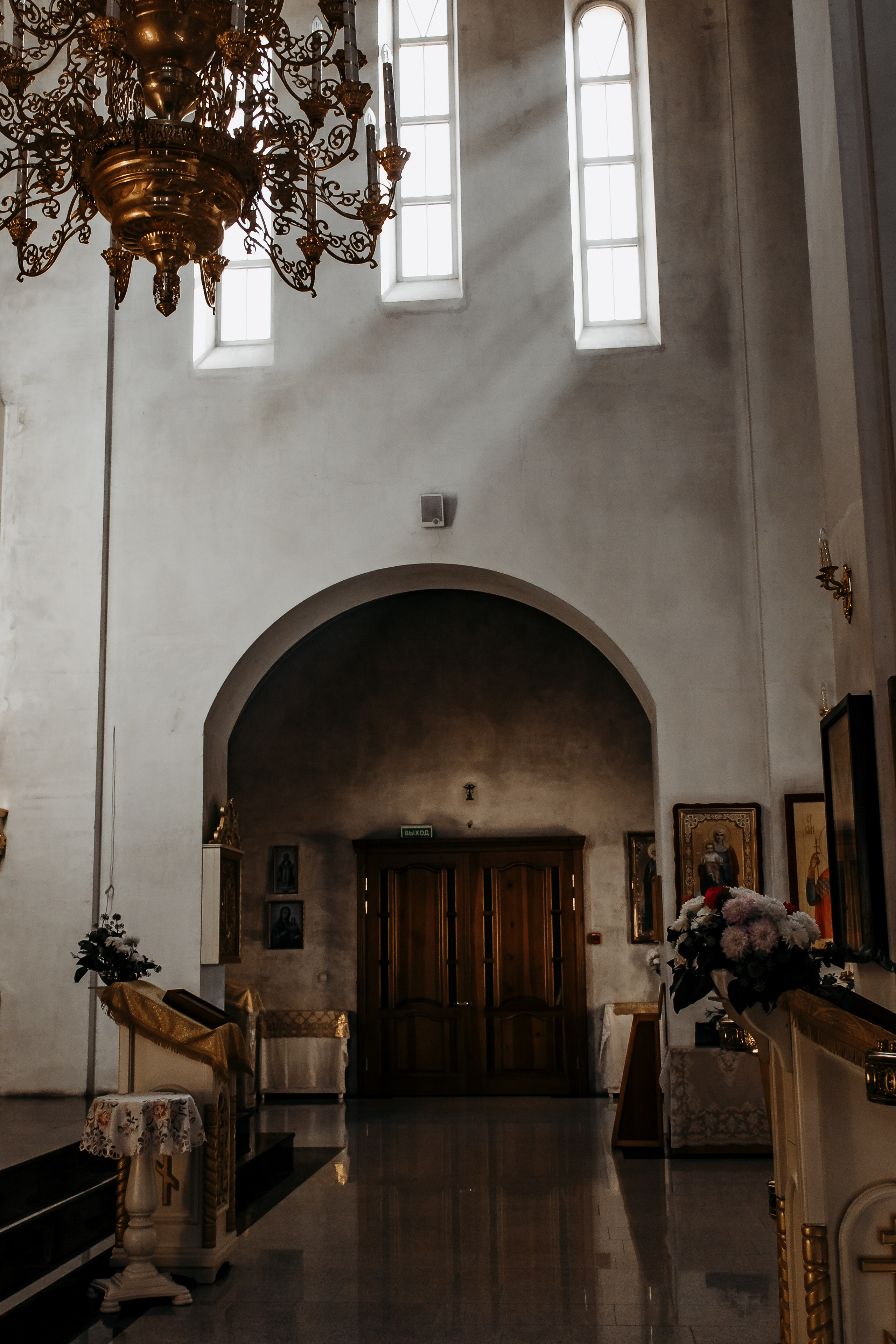 Младенец в белом платьице во время святого крещения на купеле