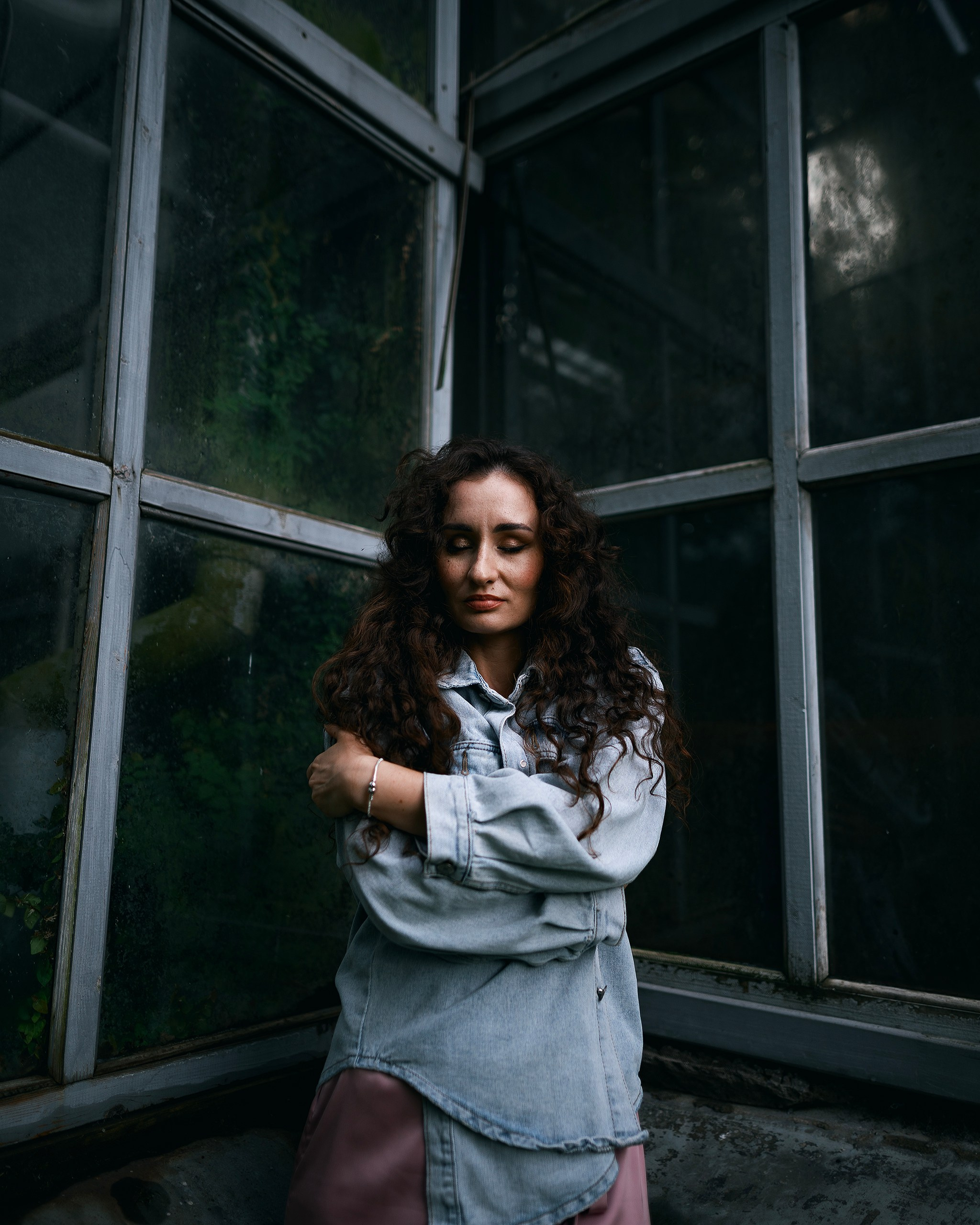 Девушка в платье стоит на фоне зелени