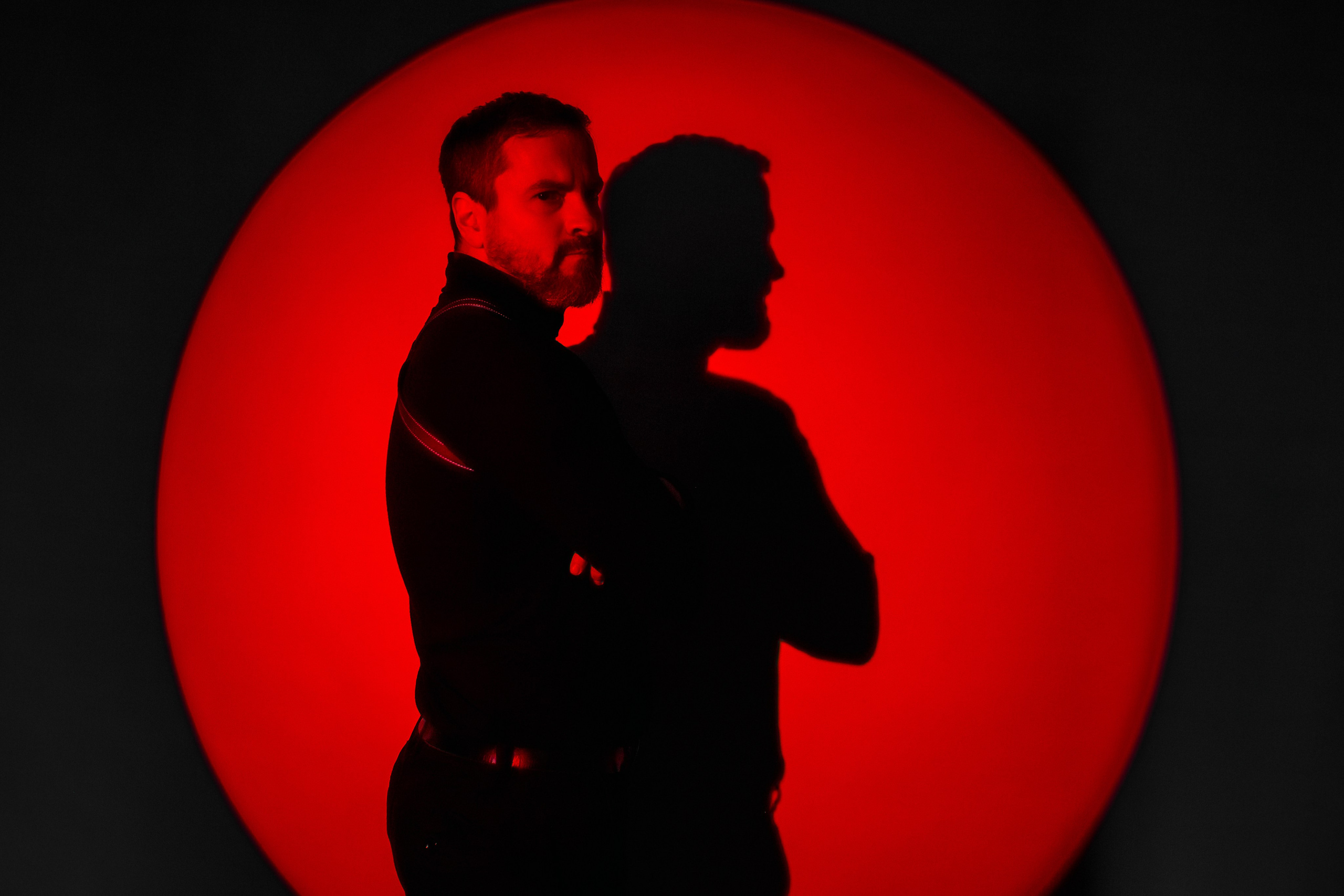 Брутальный мужчина в красном круге света