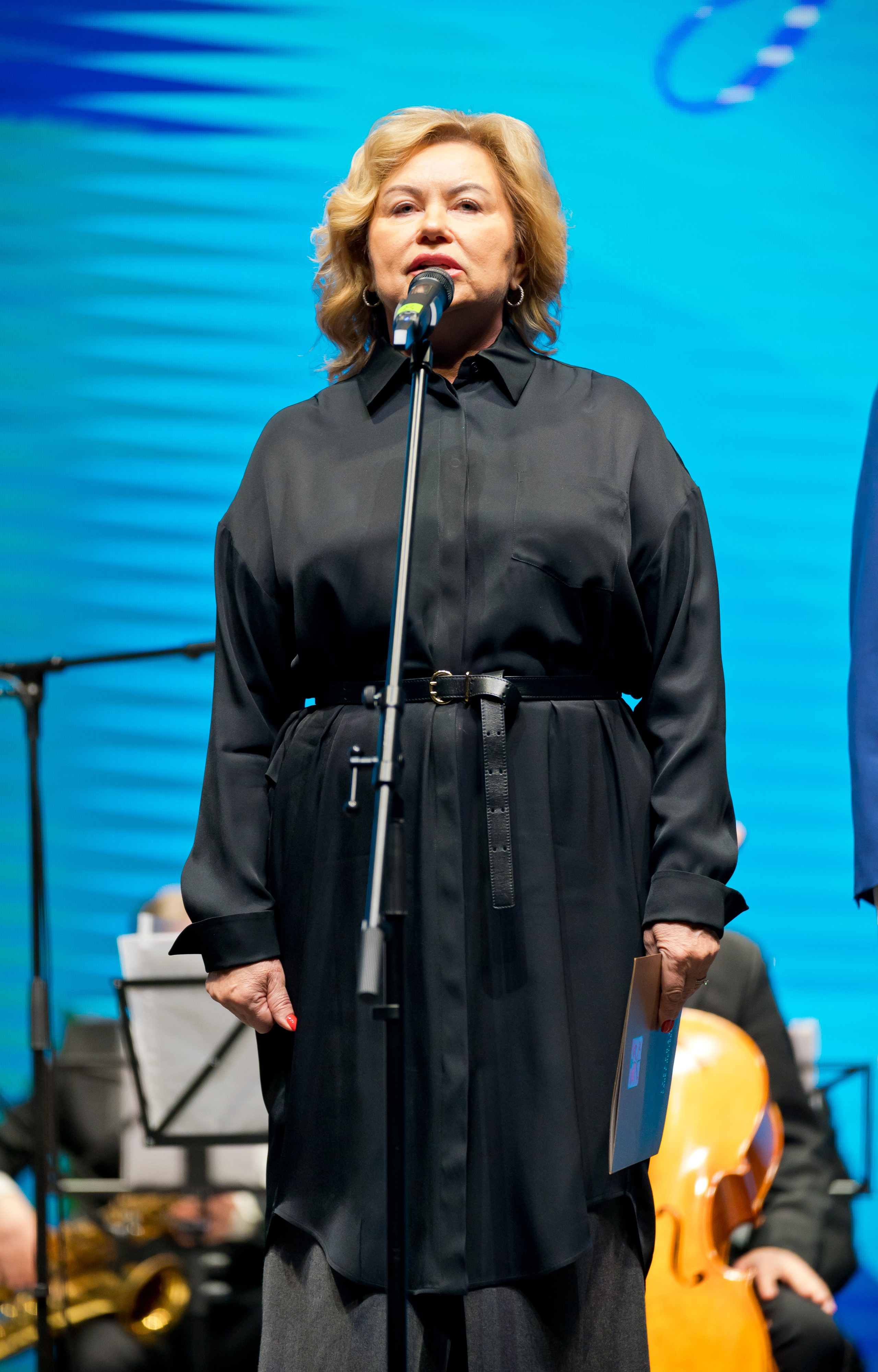 Женщина в чёрной блузке говорит речь с микрофона на торжественном мероприятии. День местного самоуправления. Фото Евгения Мальцева.