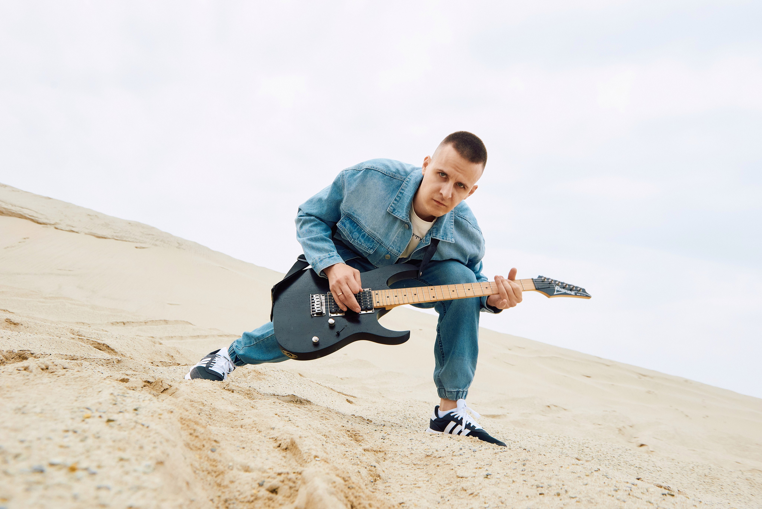 Парень играет на гитаре в пустыне