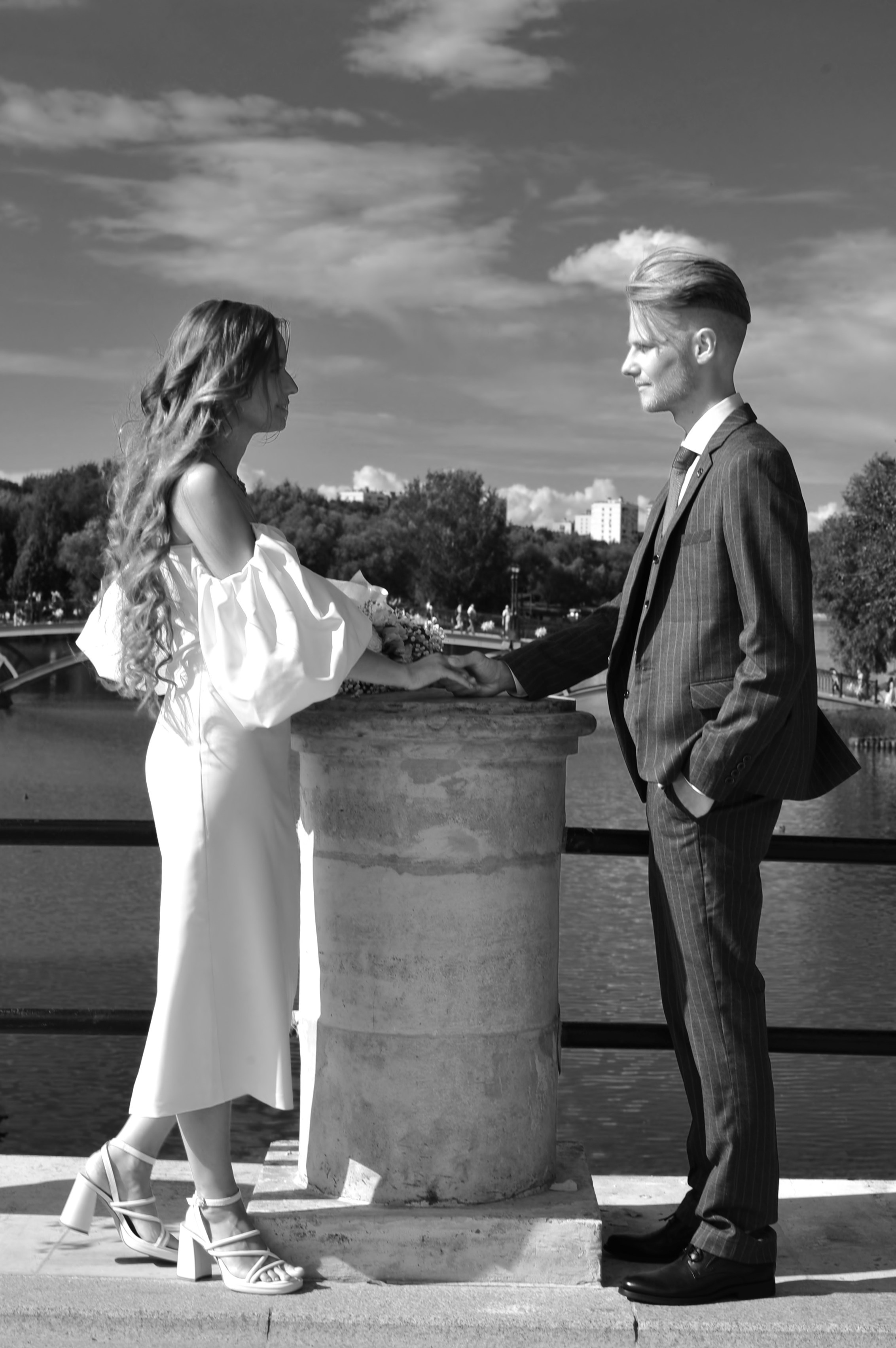 Свадьба в Царицыно летом, новобрачные держатся за руки на мосту, чёрно-белая фотография