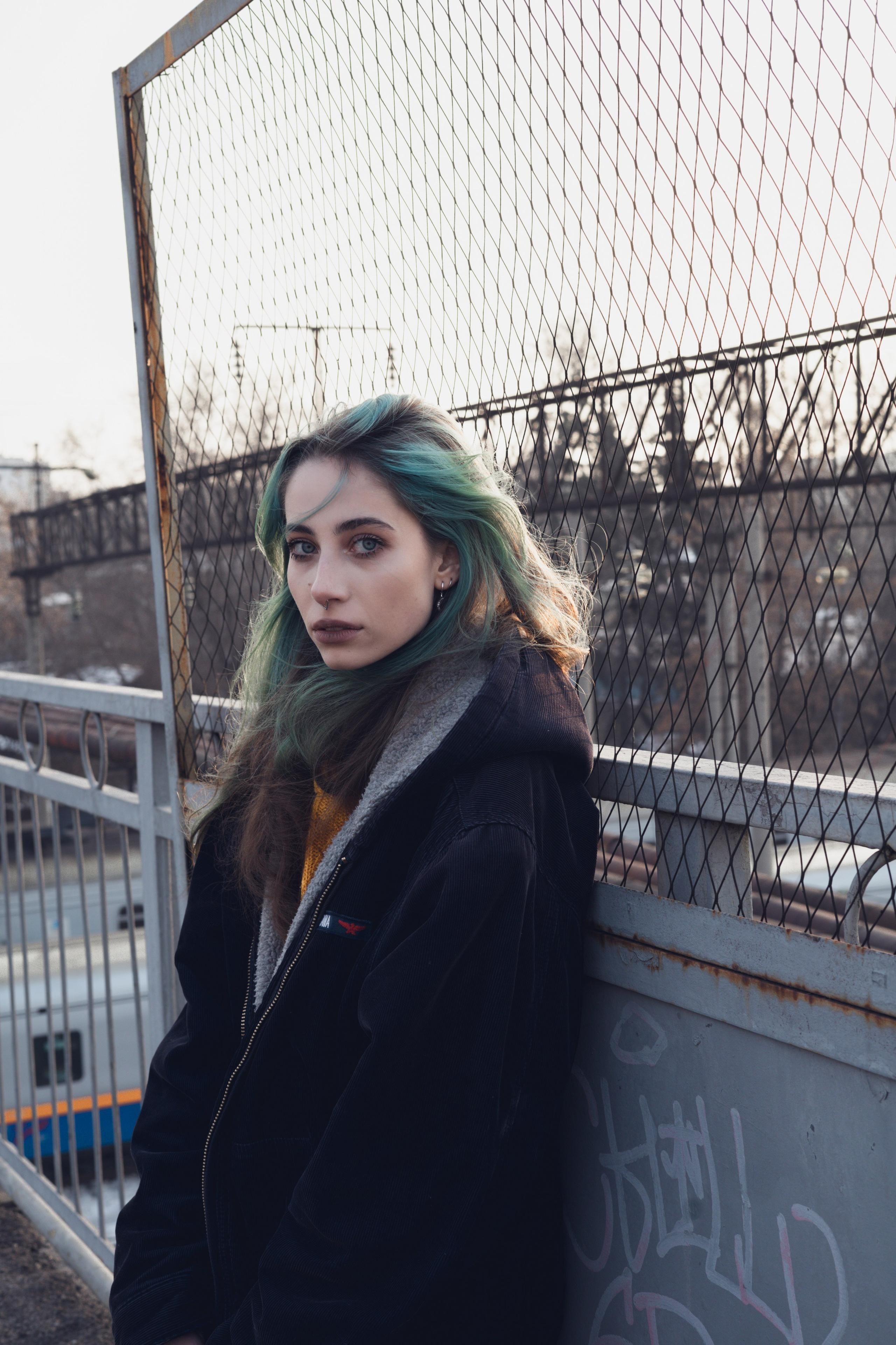Урбанистическая фотосессия: модель с зелёными волосами у граффити