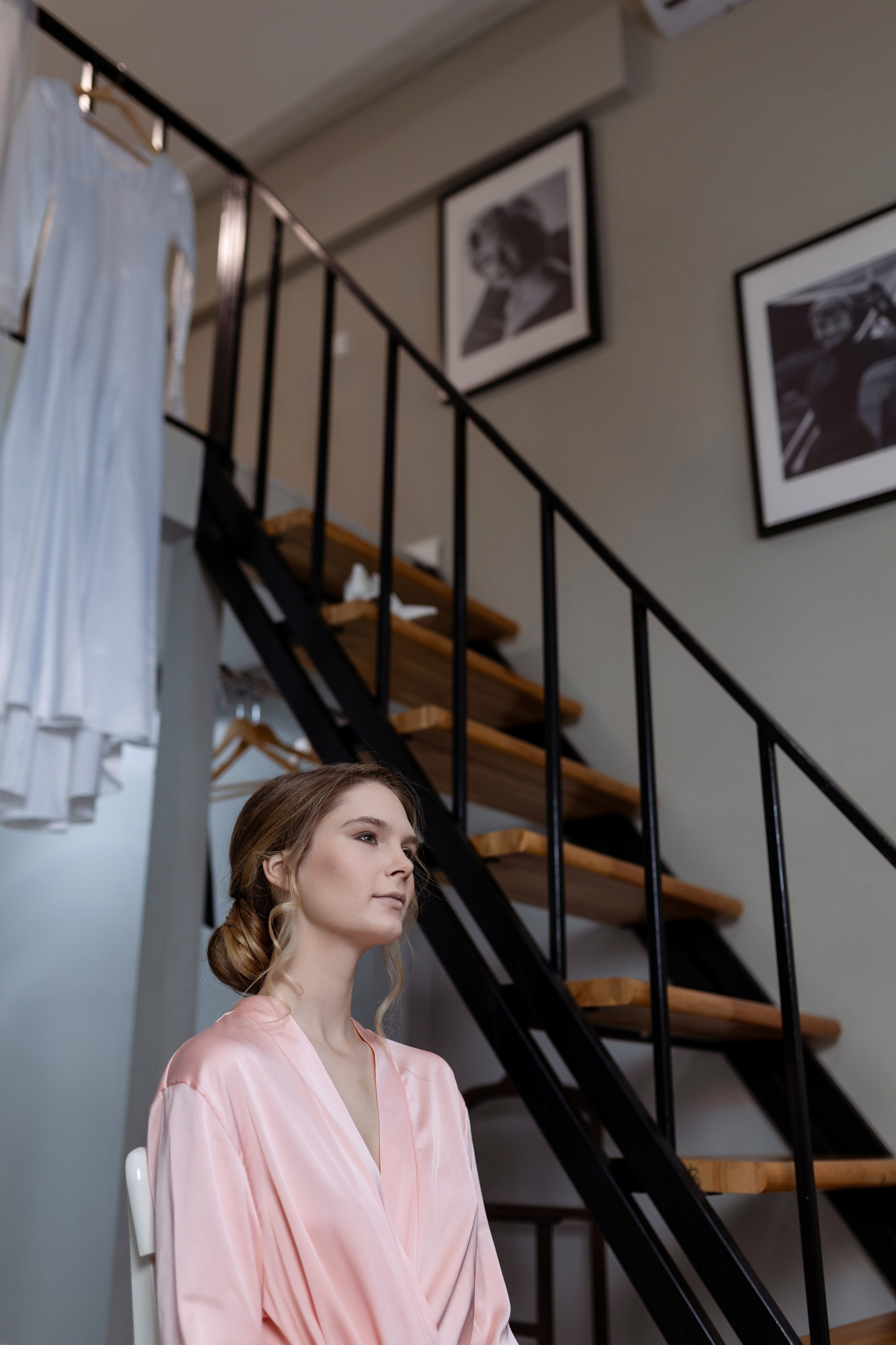 Невеста стоит у лестницы с новой прической.