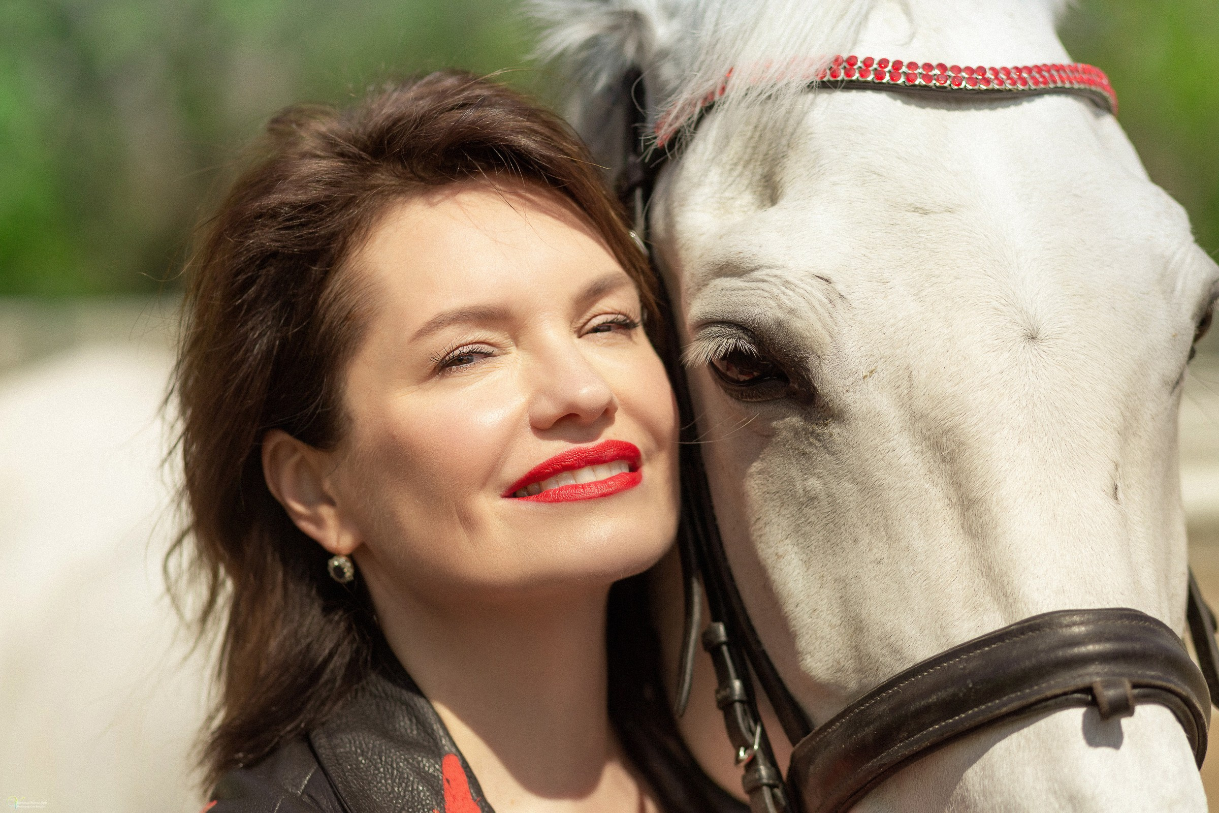 Красивая женщина и рядом белая лошадь, девушка с красной помадой и красивой улыбкой