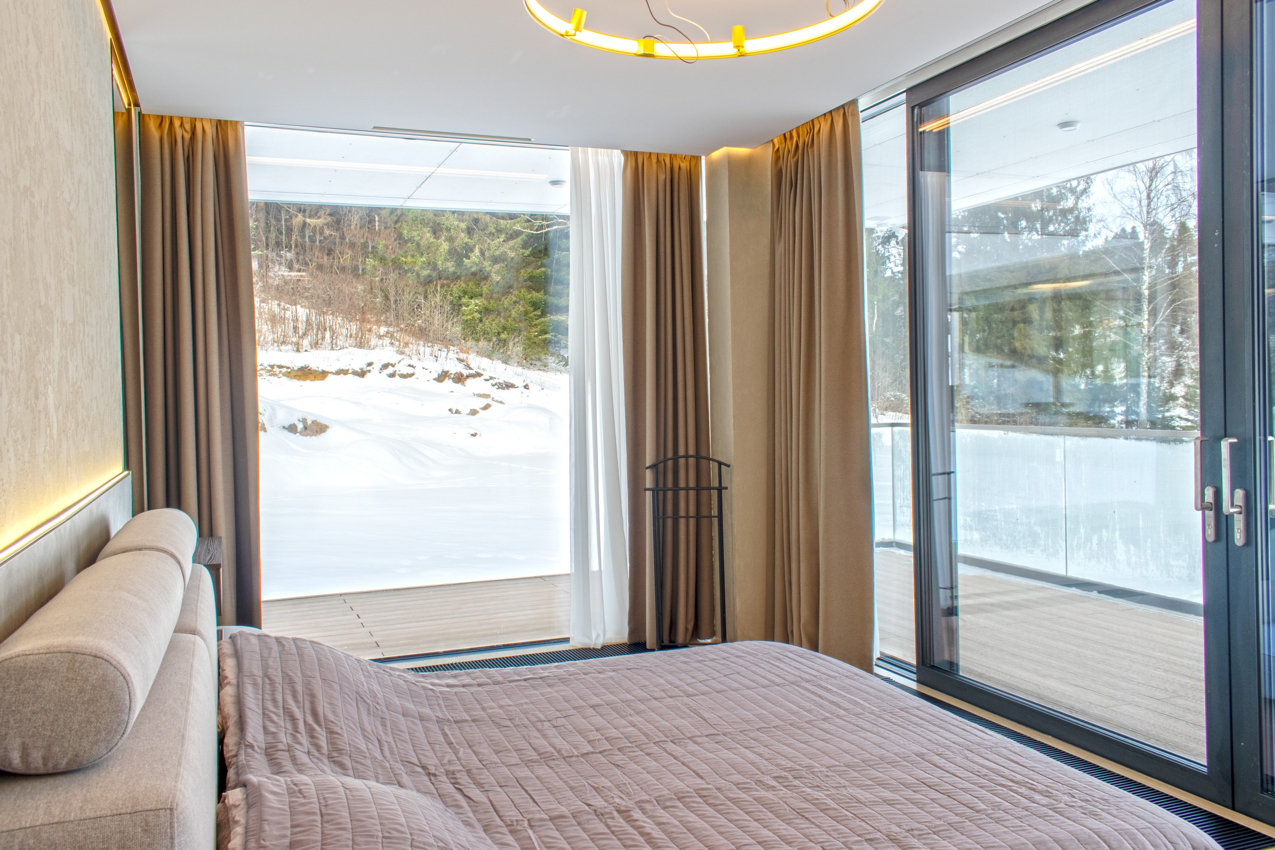 Интерьер гостевого дома для сдачи в аренду в Карелии в Сортавала. Фотосъемка спальни с большими панорамными окнами.