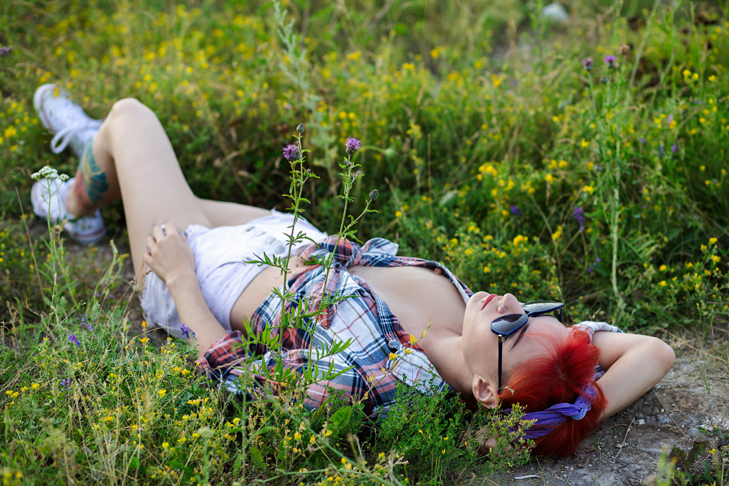 провинциальная девушка  валяется на травке, в черных очках, ее рубашка распахнута,видно грудь,