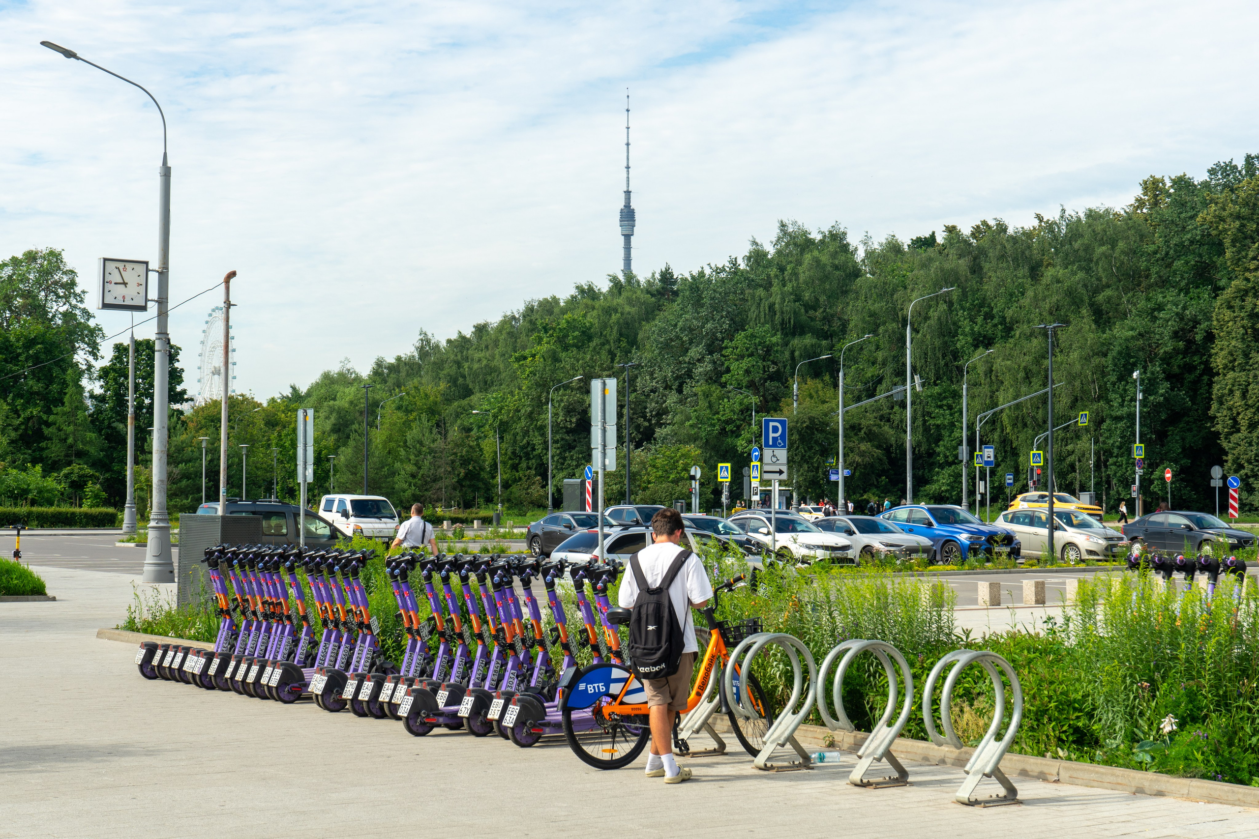 электросамокаты парковка, парень мужчина выбирает электросамокат