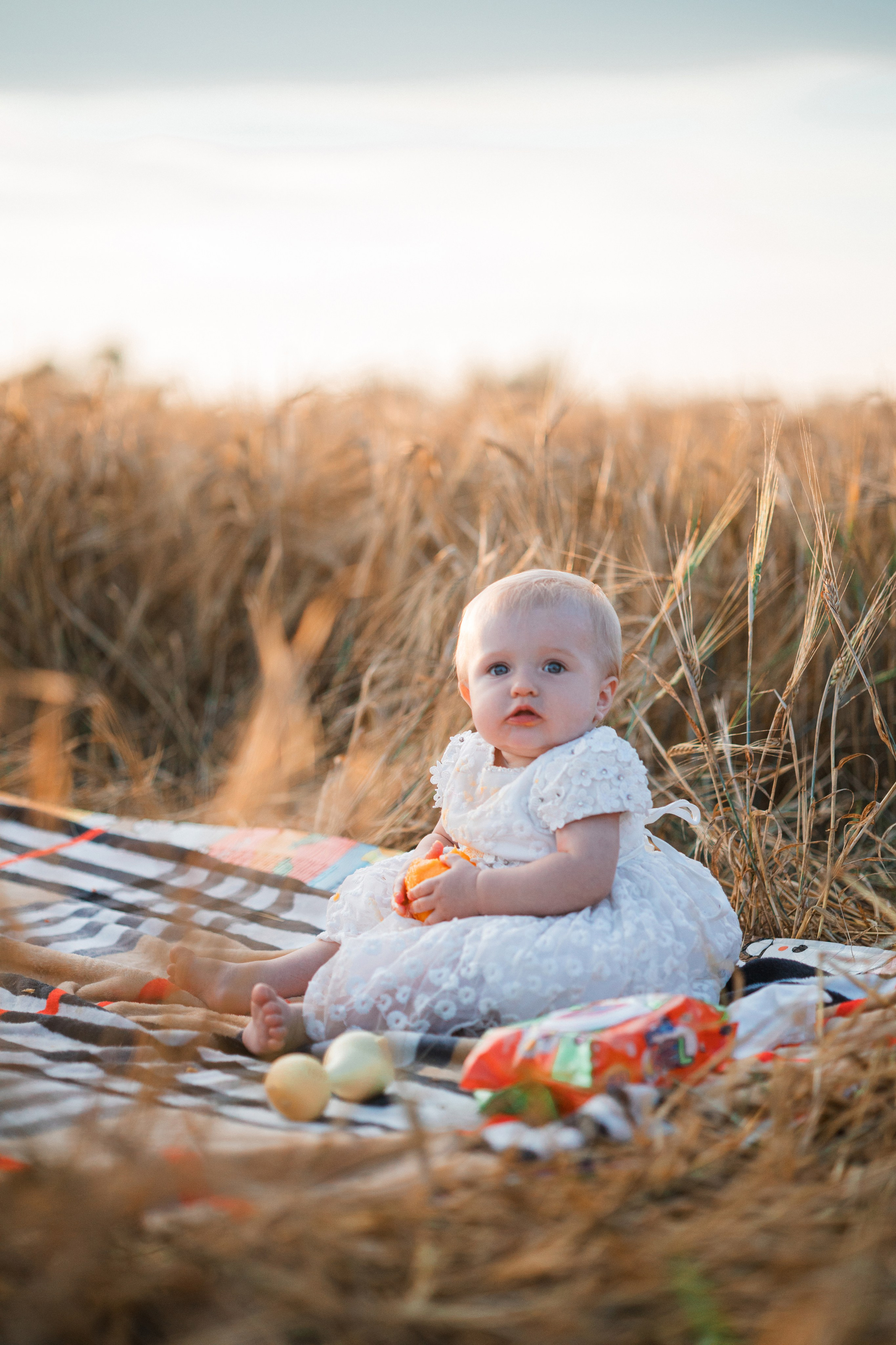 Ребенок играет в поле при закате.