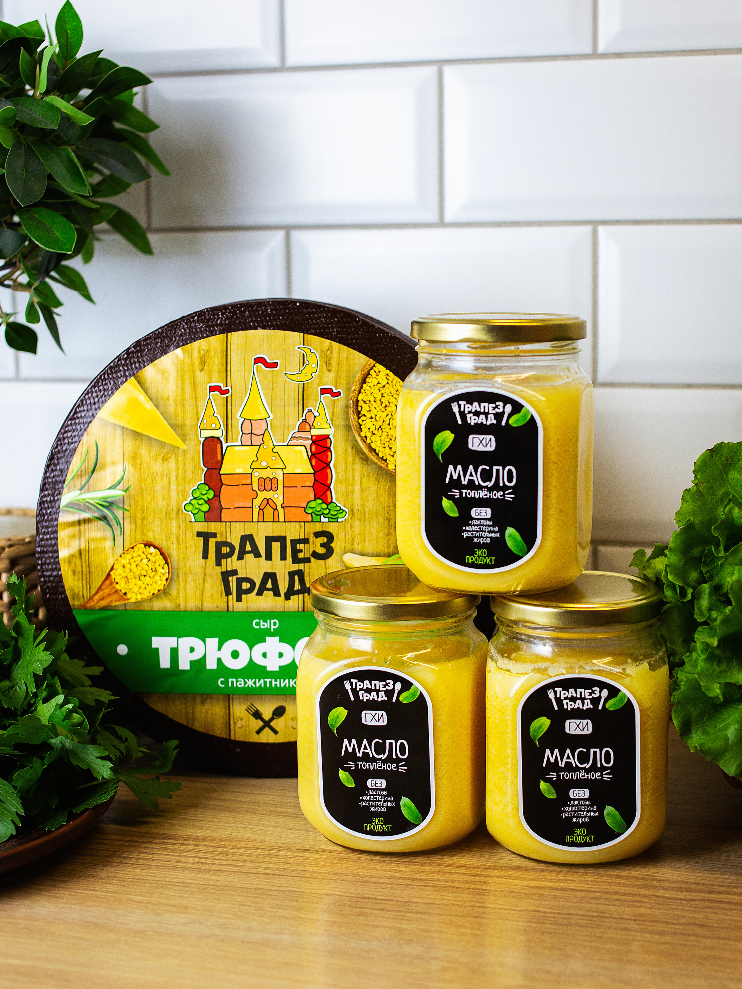 на  столе стоит несколько  банок   с топленным маслом  и круглый сыр
