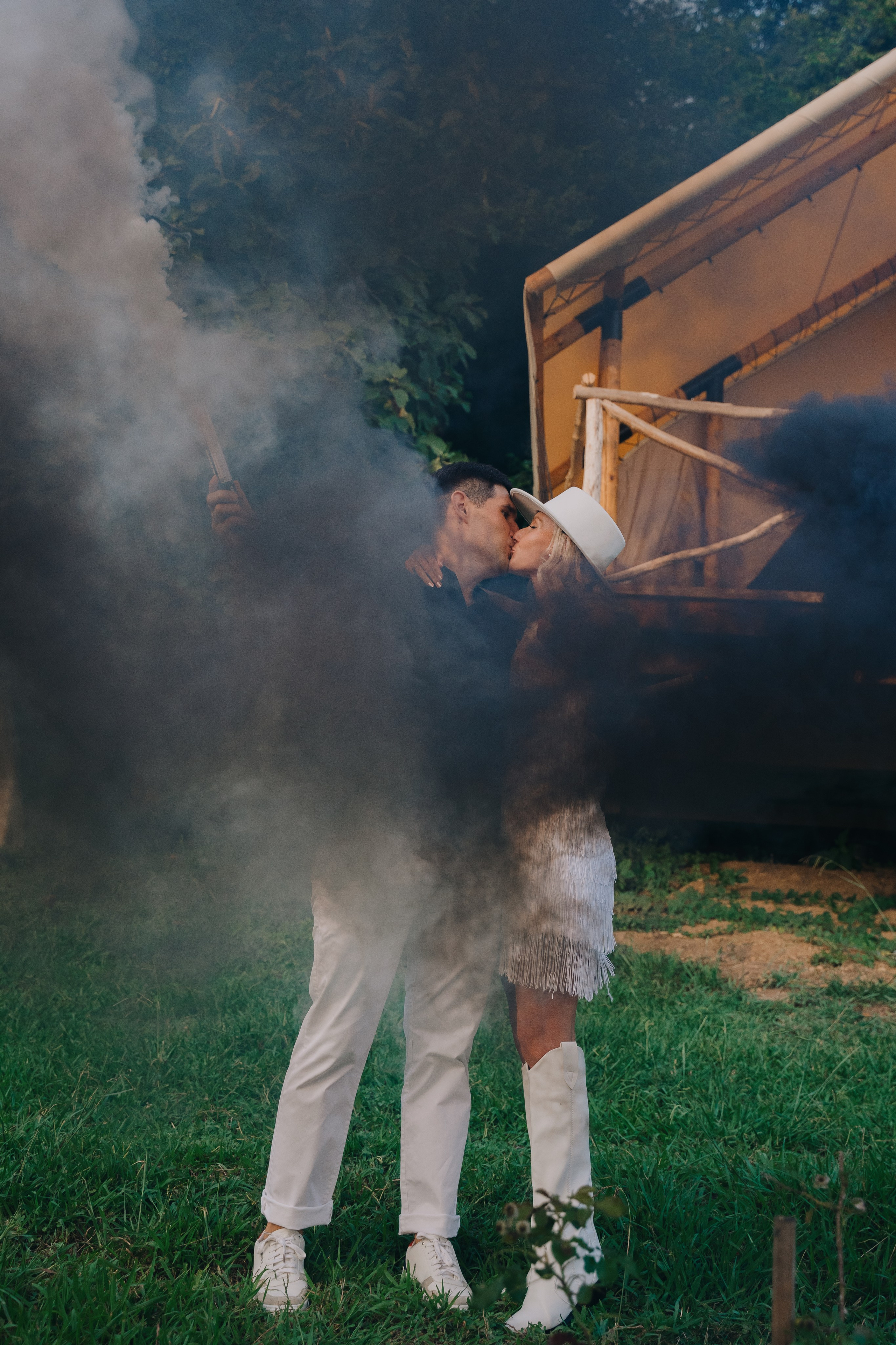 Фотография целующими пары с дымовыми шашками в руках