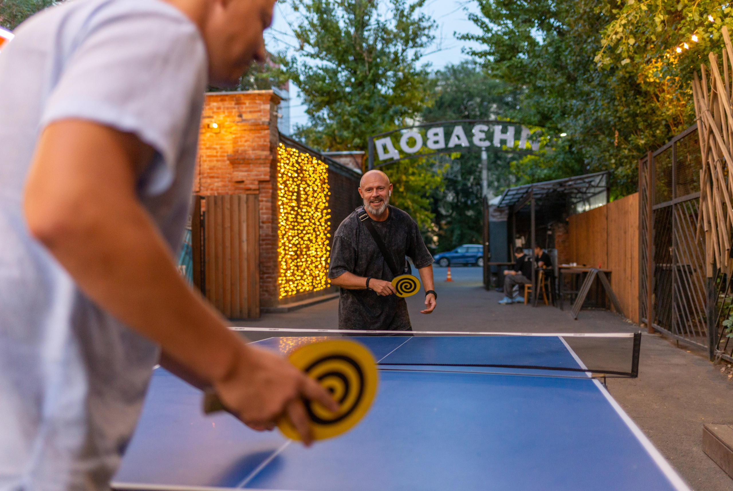 Двое мужчин играют в настольный теннис в Воронеже на Винзаводе.