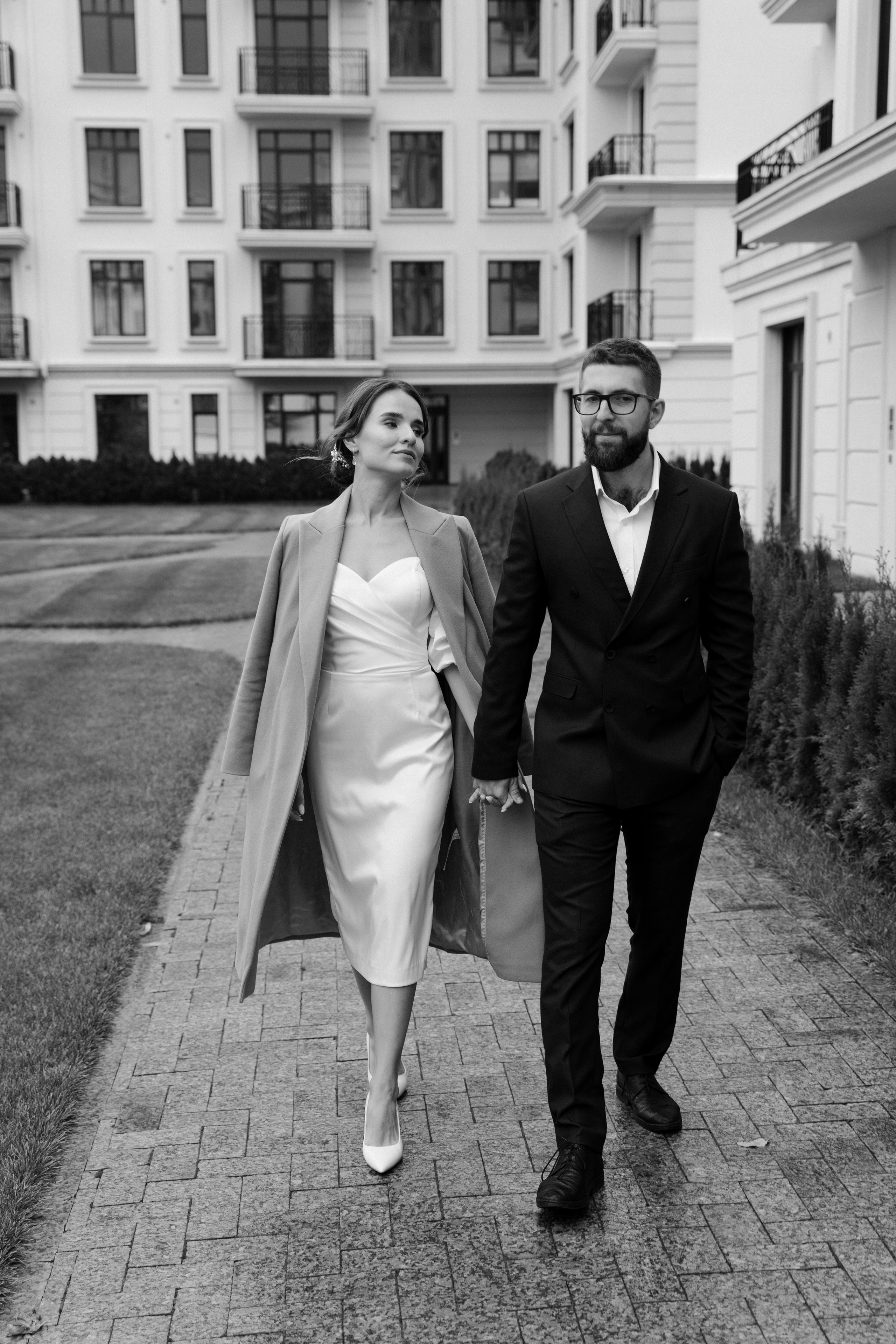 Молодожены идут по улице и держатся за руки в отеле Рамада