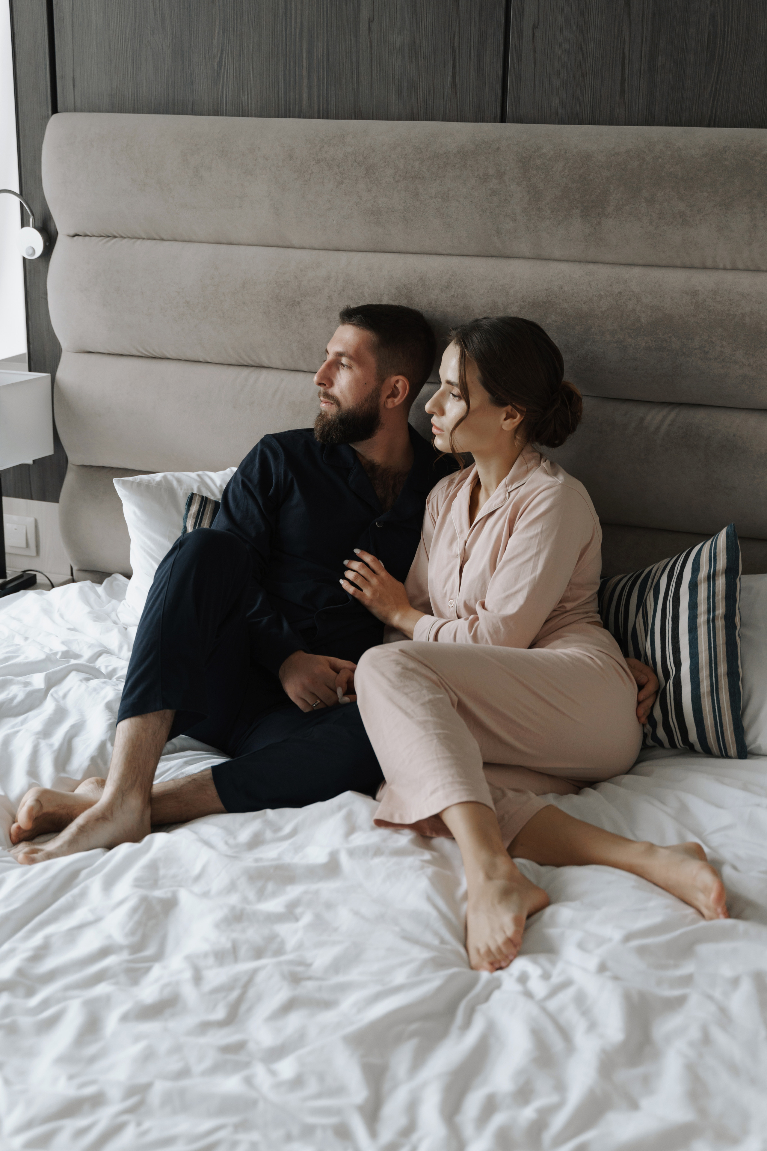 Утро жениха и невесты в отеле. Пара на кровати в пижамах.