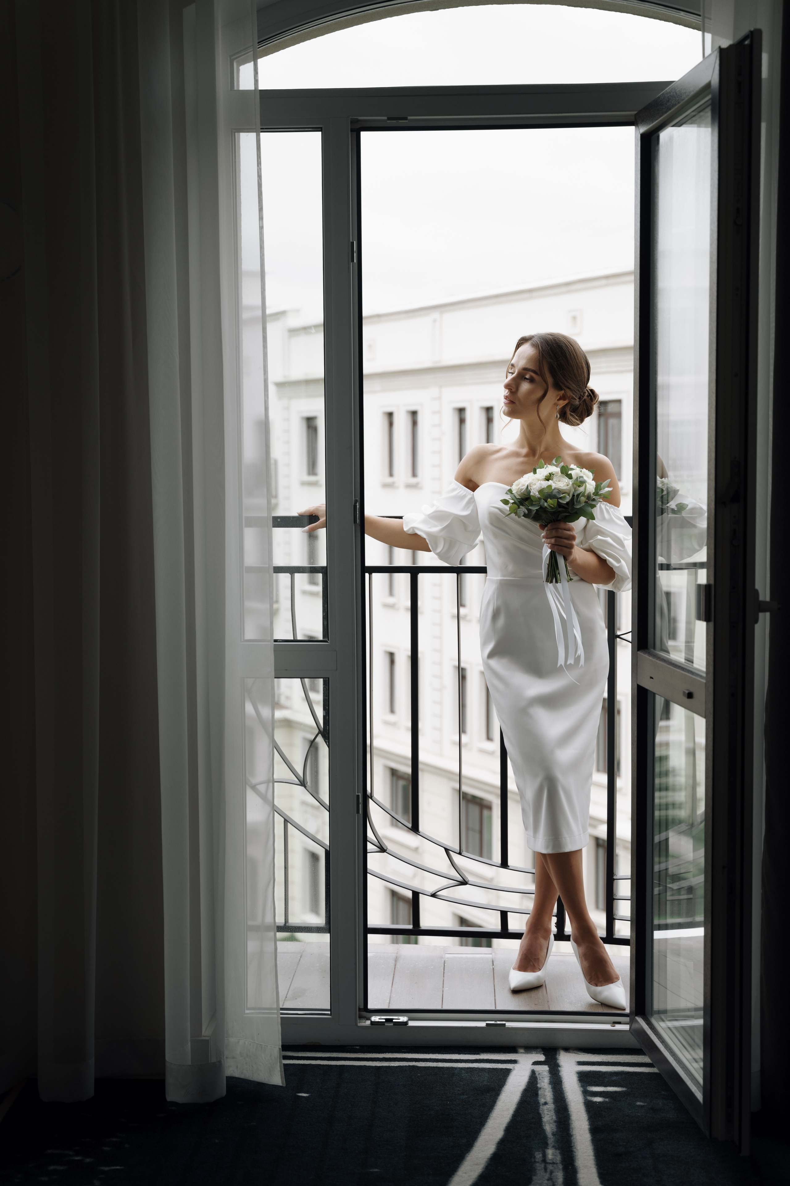 Фото невесты с букетом на балконе отеля
