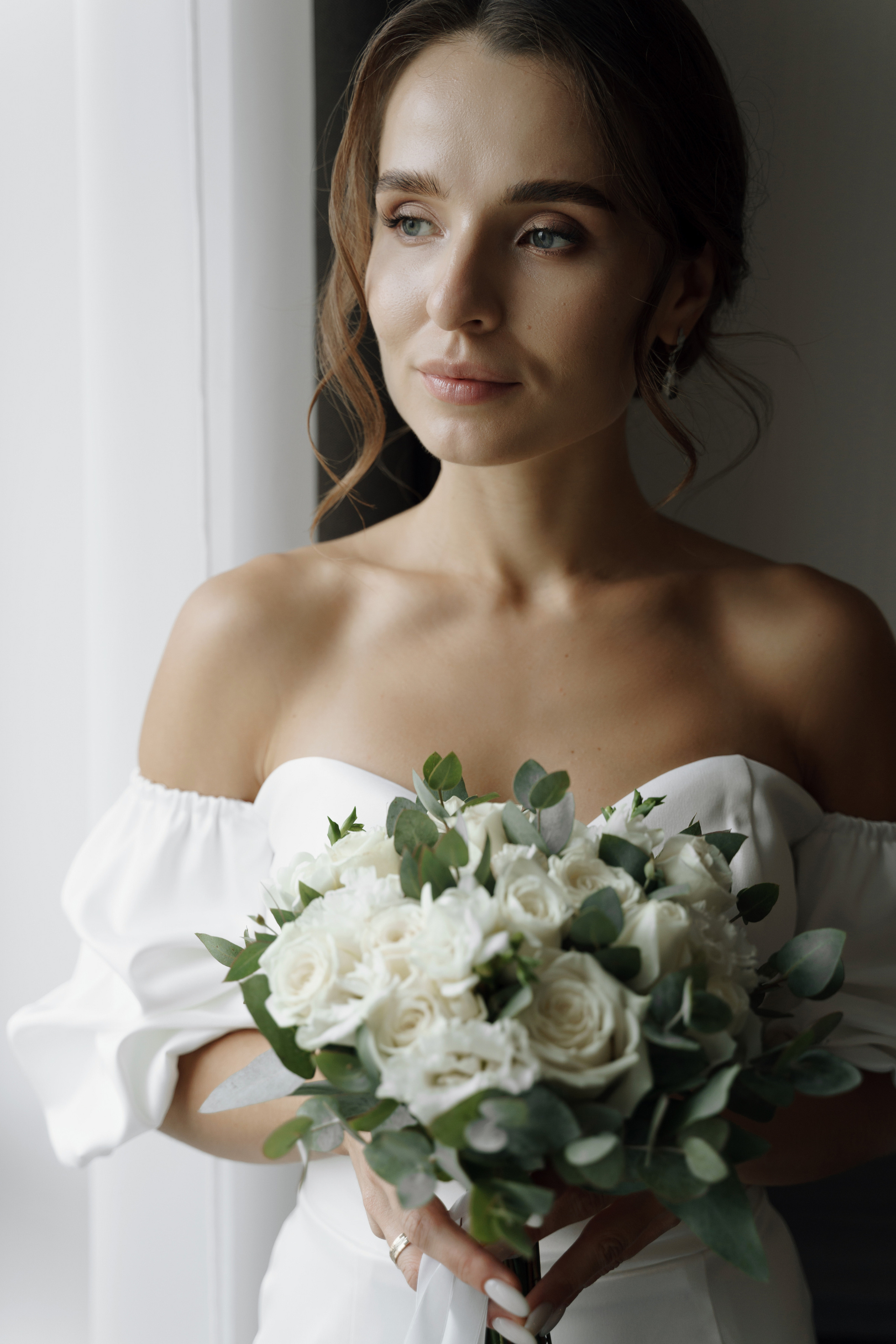 Портрет невесты с букетом цветов, смотрит в окно.