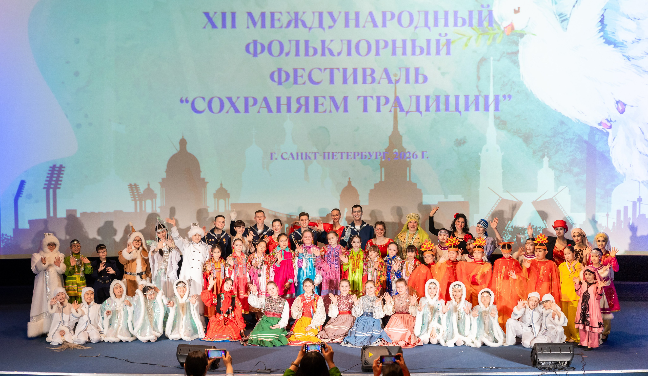 Финалисты и лауреаты XII Международного фольклорного фестиваля «Сохраняем традиции» с грамотами и кубками на сцене. Санкт-Петербург 2026. Фото: Евгений Мальцев.