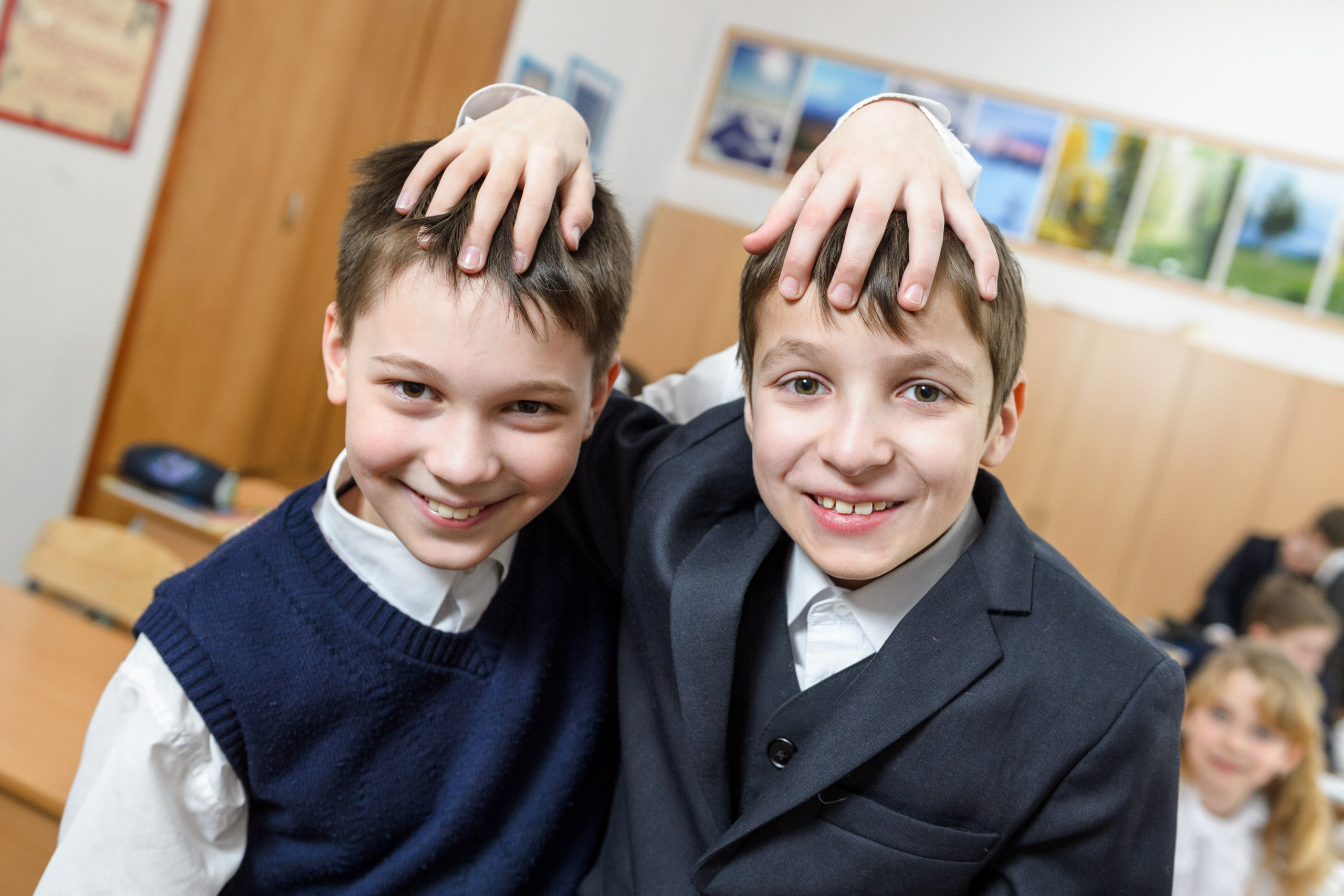 Два ученика улыбаются в классе после урока