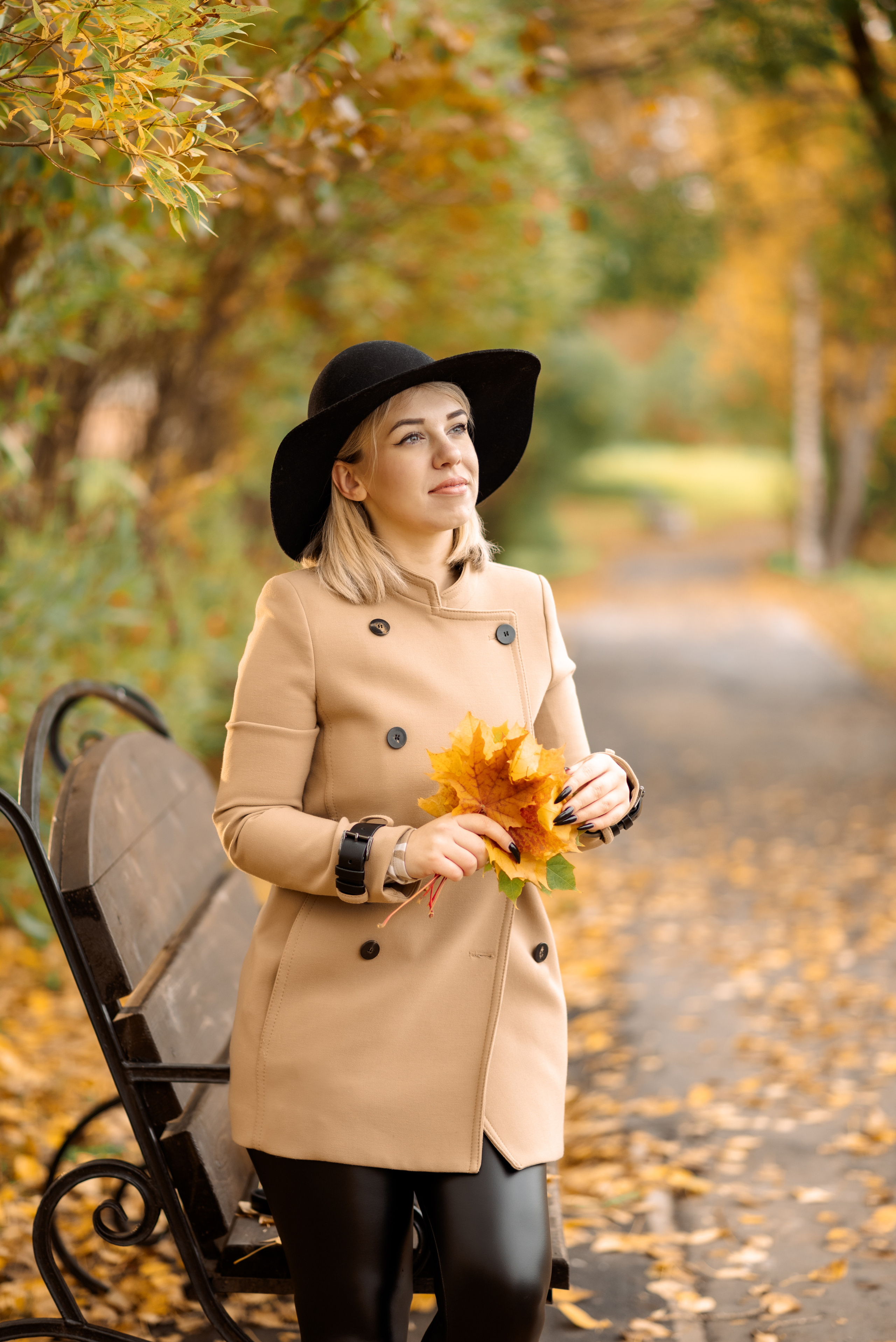 девушка в пальто и шляпе на скамейке в осеннем парке