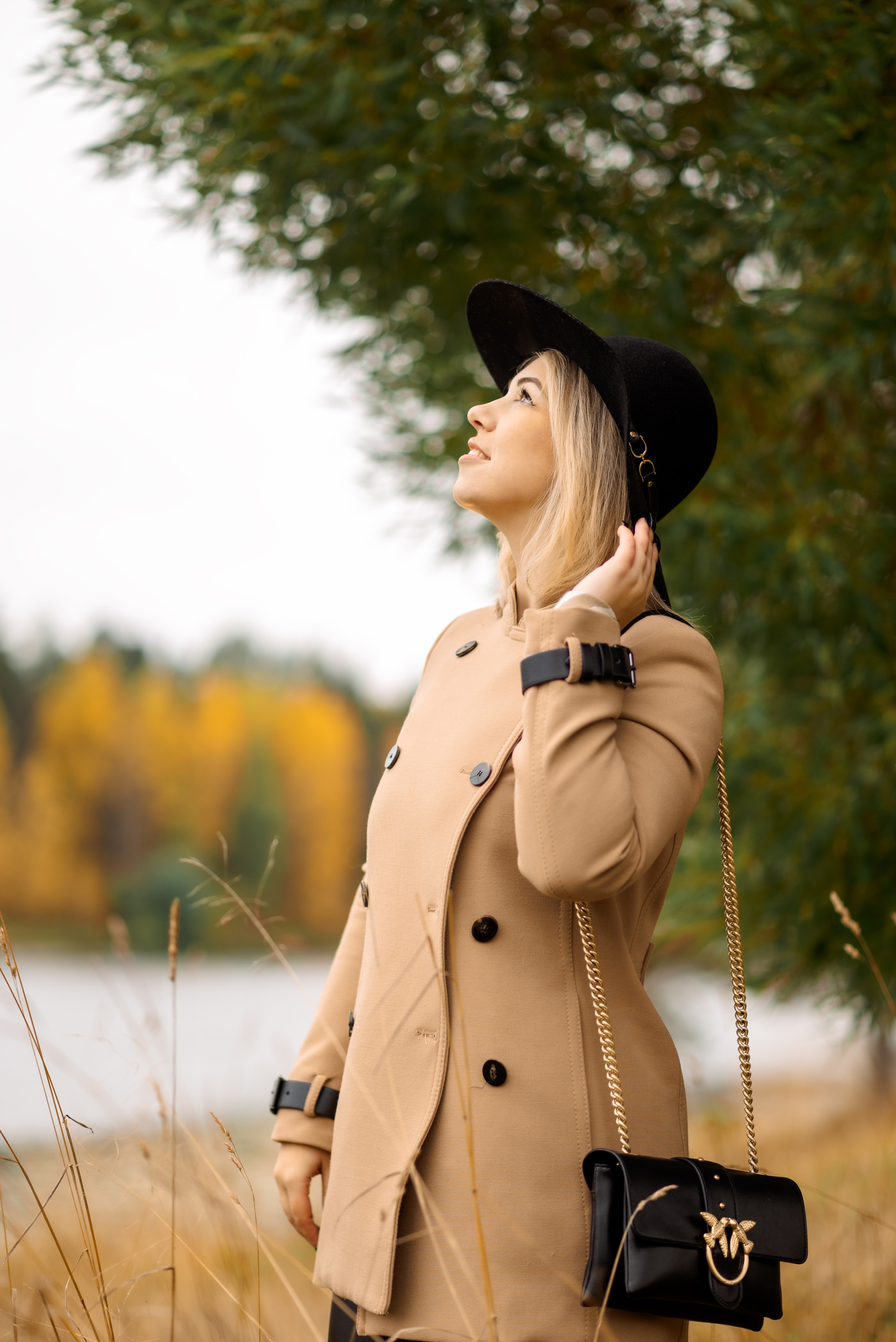 портрет девушки на берегу озера , придерживает шляпу рукой