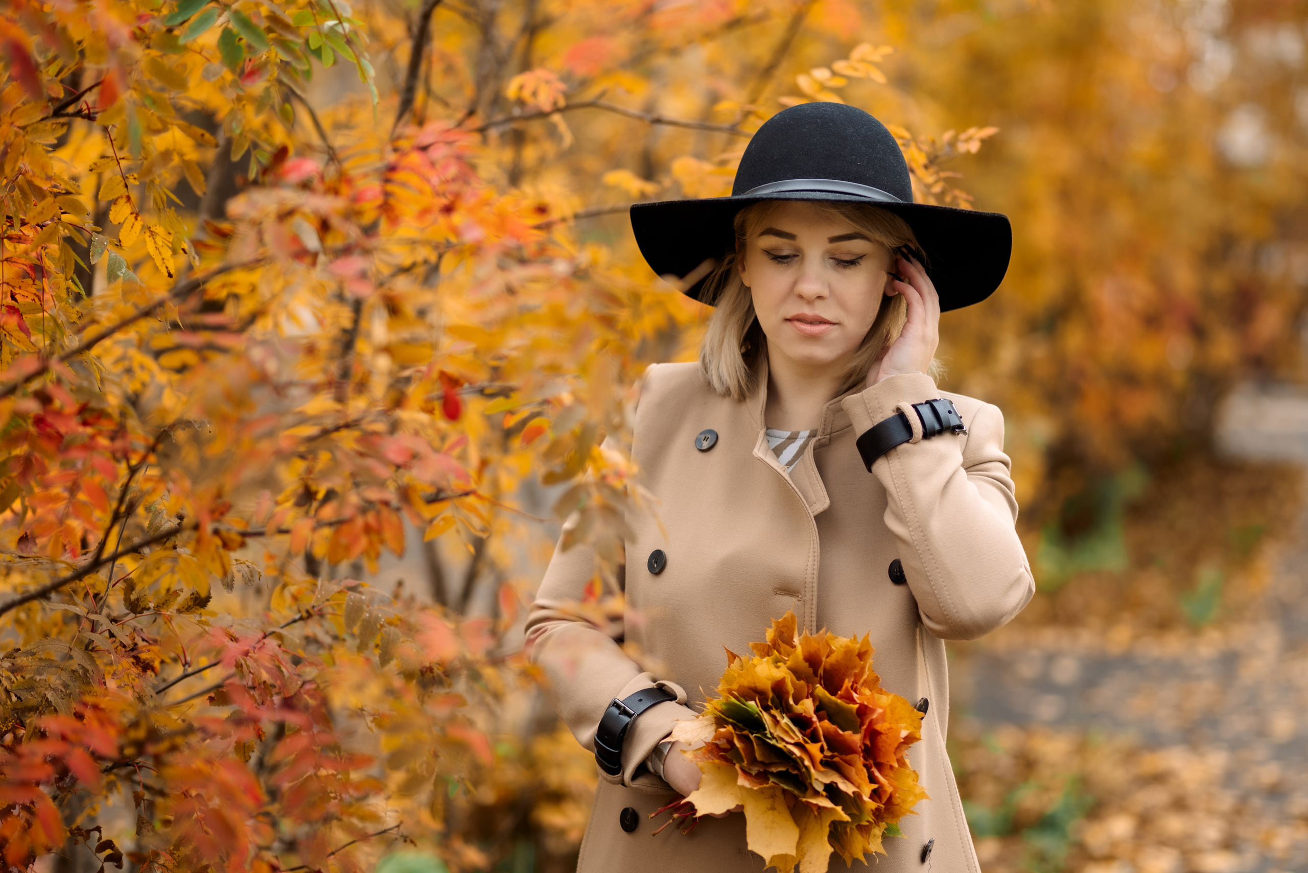 девушка держит яркие опавшие листья