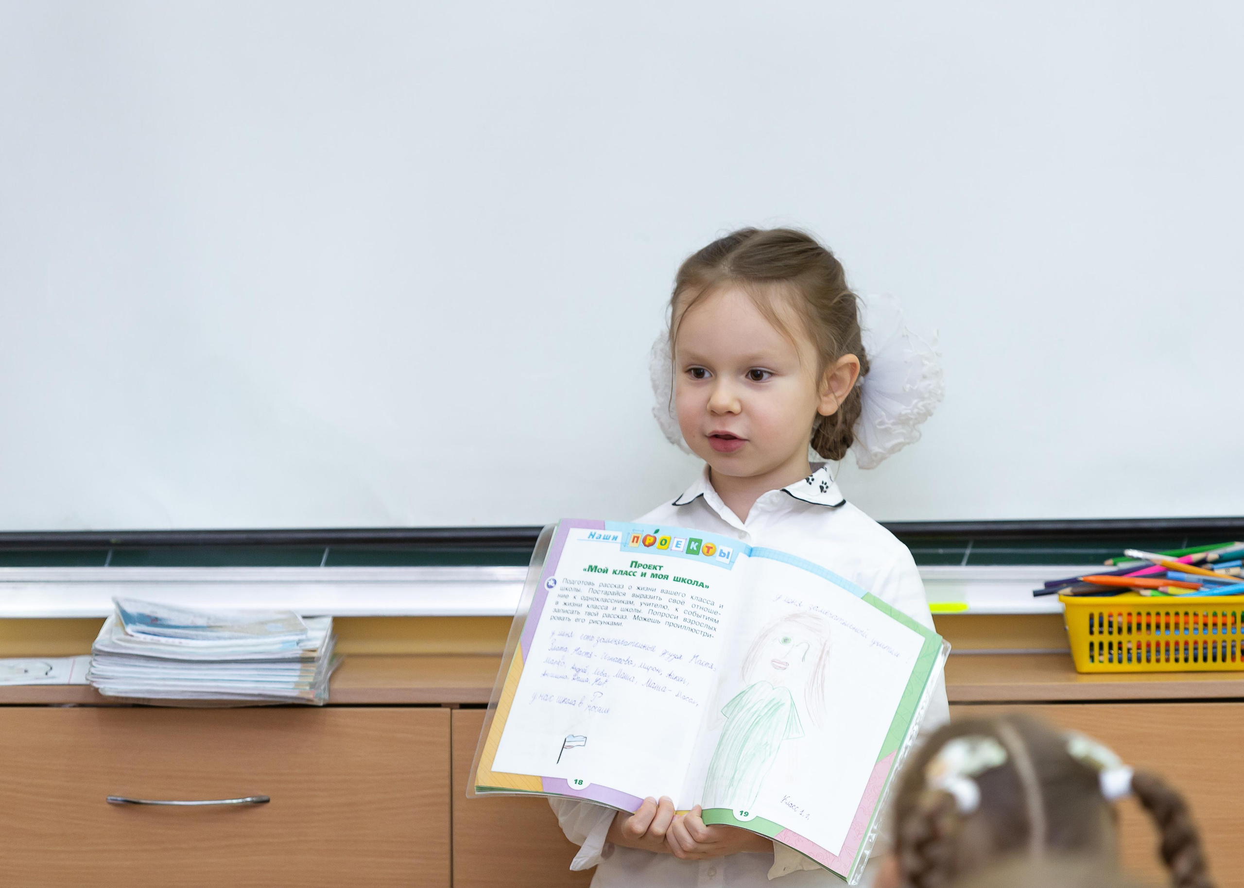 Девочка с учебником у доски