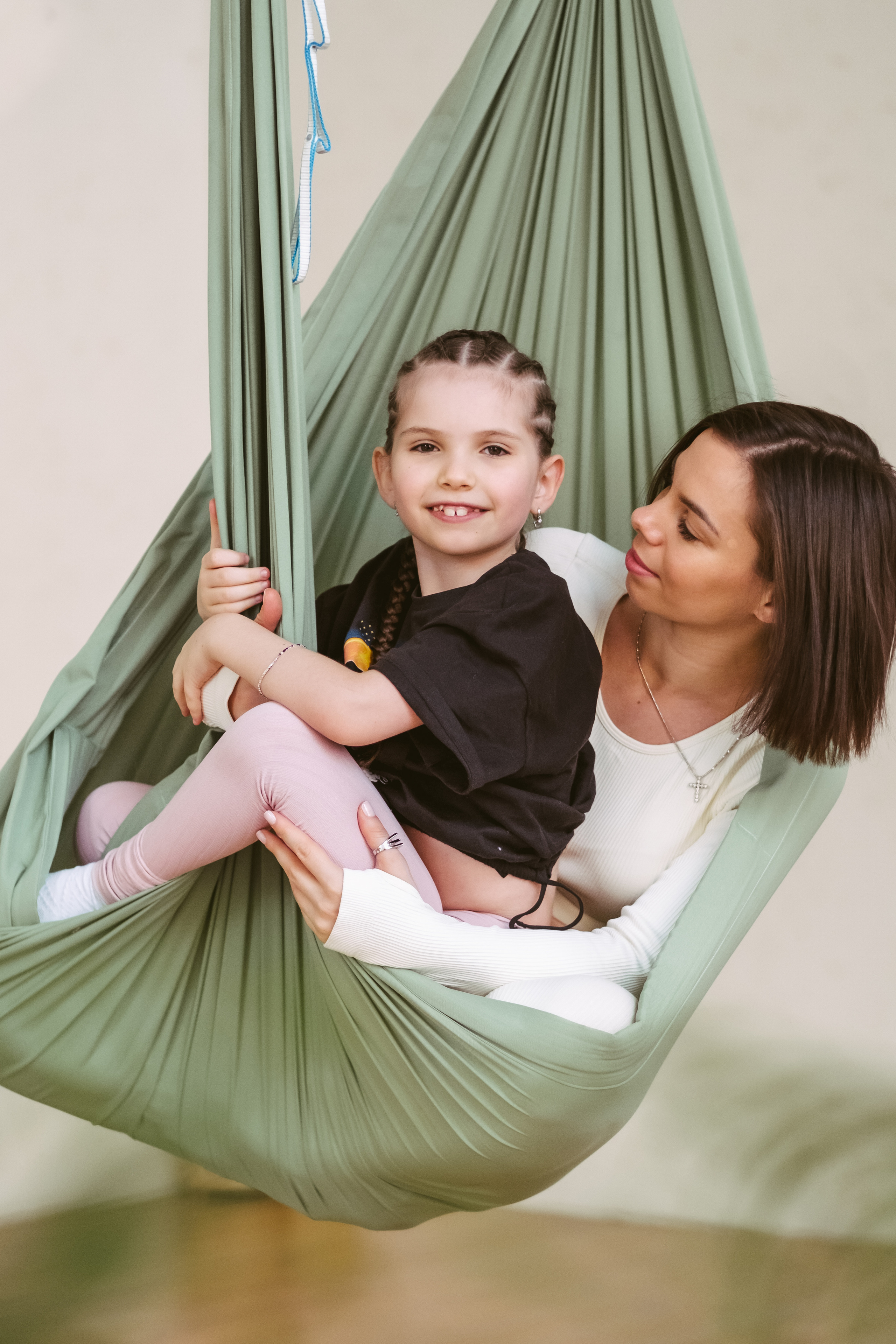 Мама и дочь в гамаке для аэройоги